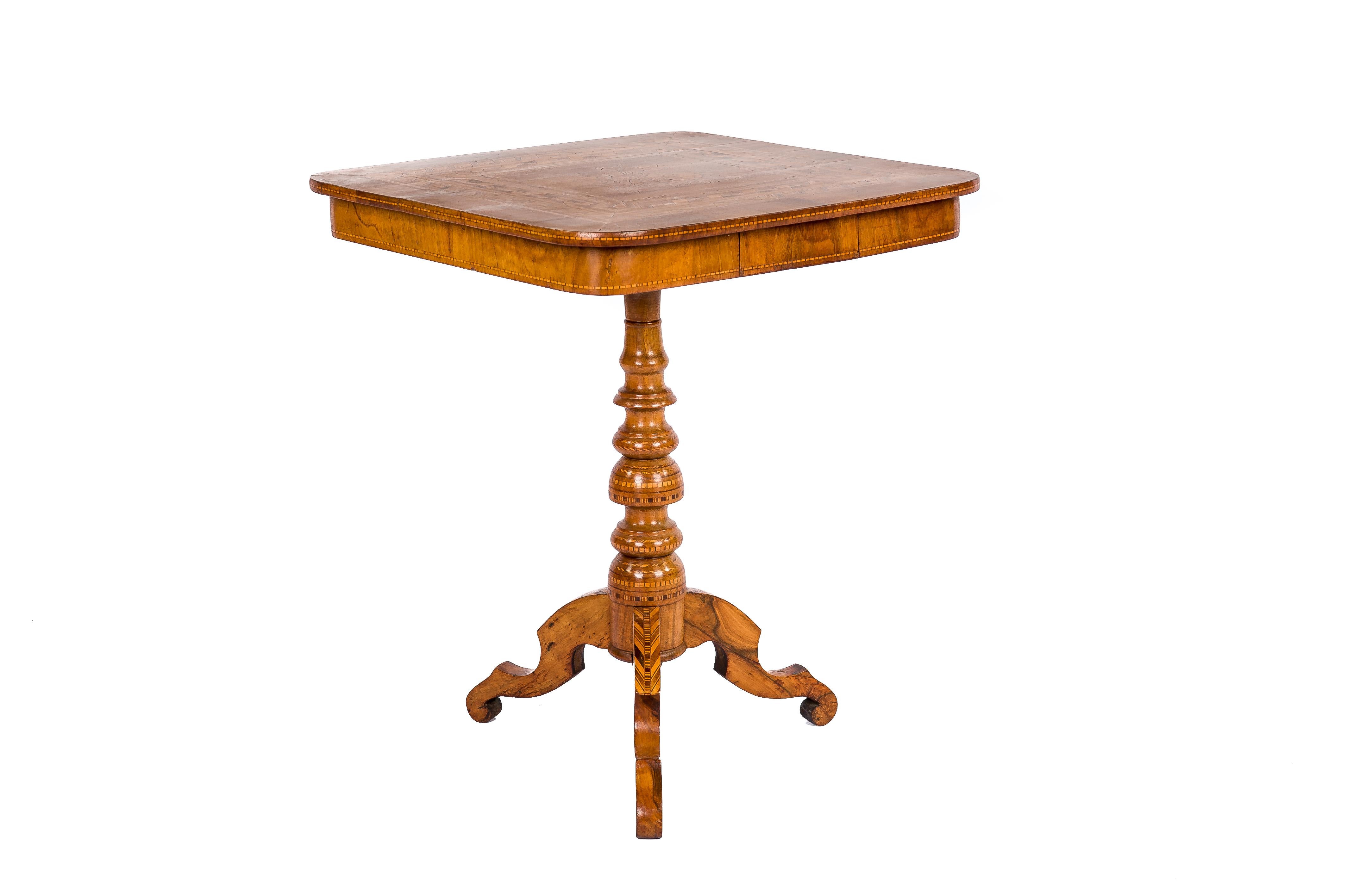 Ein schöner Beistelltisch mit kippbarer Platte, der um 1870 in Italien hergestellt wurde. Der Tisch ist stark mit Intarsien verziert, die aus verschiedenen Edelhölzern wie Olivenholz, Nussbaum, Mahagoni und Obstholz gefertigt sind. Der Tisch hat