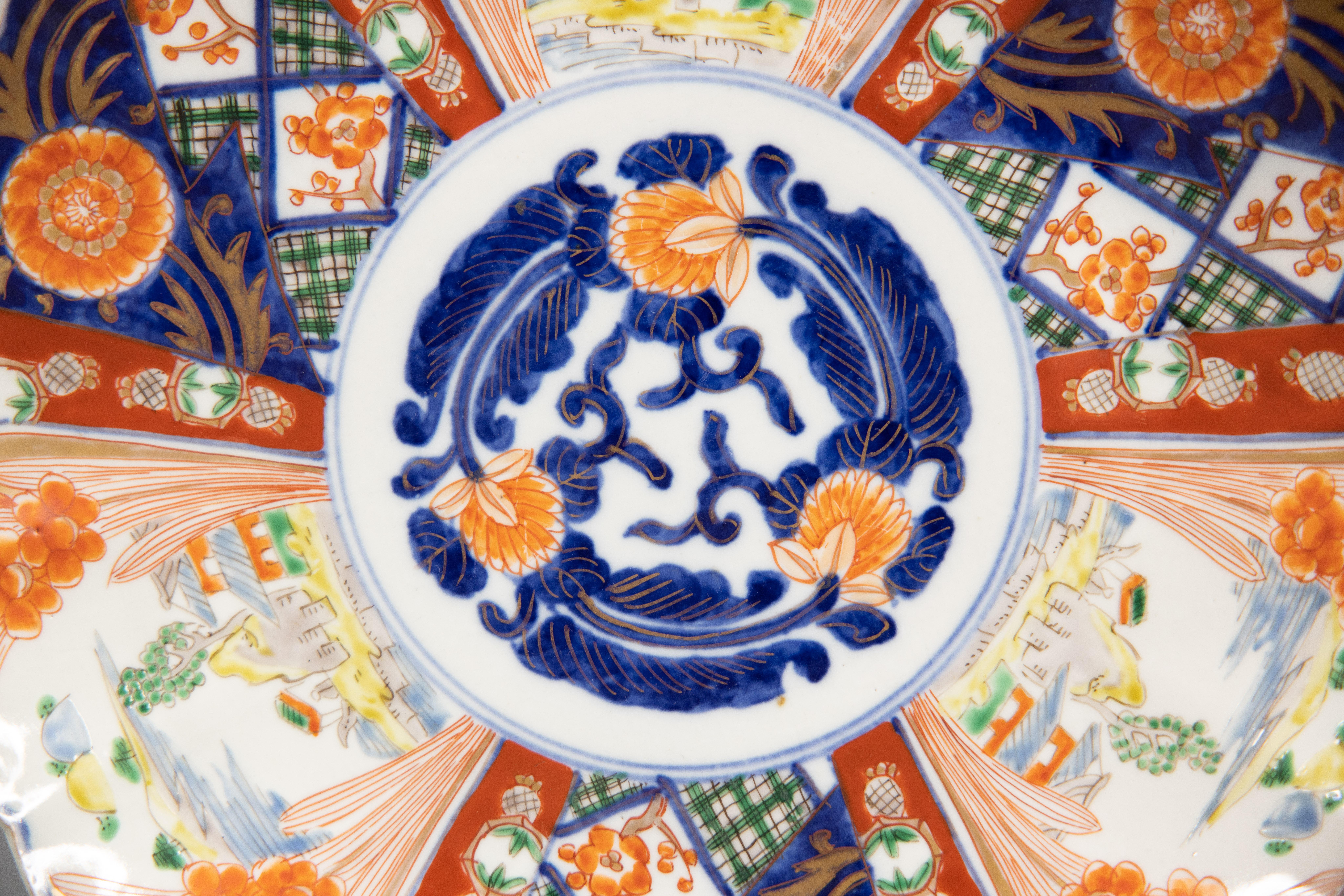 A gorgeous 19th-Century Japanese Imari porcelain charger with a hand painted floral design in the traditional Imari colors. This fine large plate has lovely scalloped edges and is quite heavy, weighing over 2 lbs. It's in excellent condition and