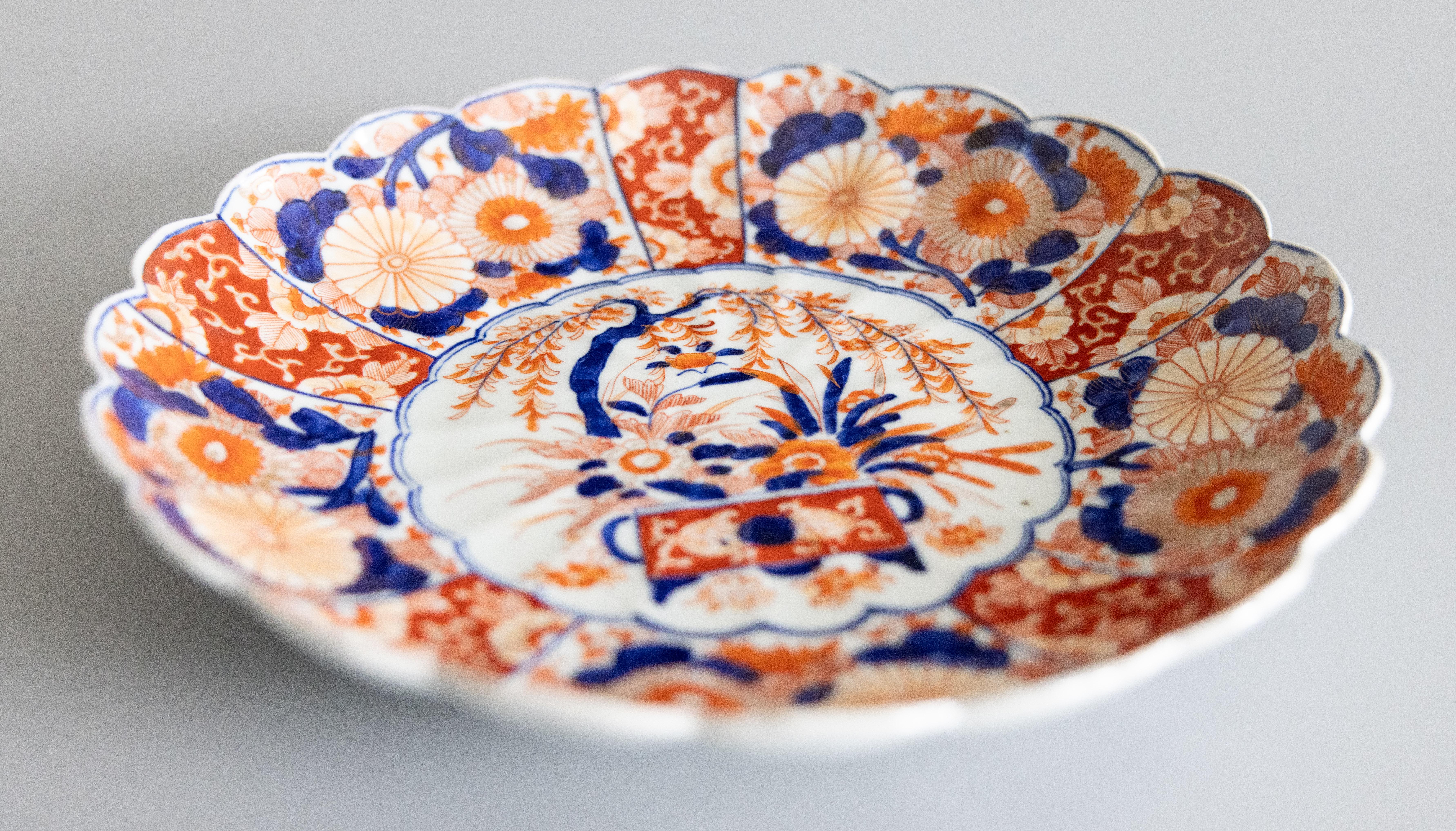 Uno splendido caricatore in porcellana Imari del periodo Meiji del XIX secolo con decorazioni floreali dipinte a mano nei tradizionali colori Imari. Questo bel piatto di grandi dimensioni ha un bel design a coste e bordi smerlati ed è piuttosto