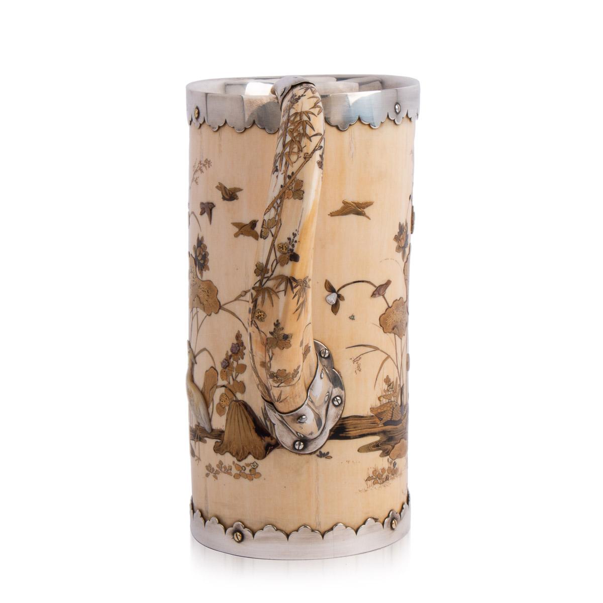 Antique 19th century Japanese Meiji period shibayama and silver mounted tankard, the tusk body decorated in gold lacquer, mother of pearl and hard stone with water fowl in a lotus pond, set with a clear glass bottom. Hallmarked English silver (925