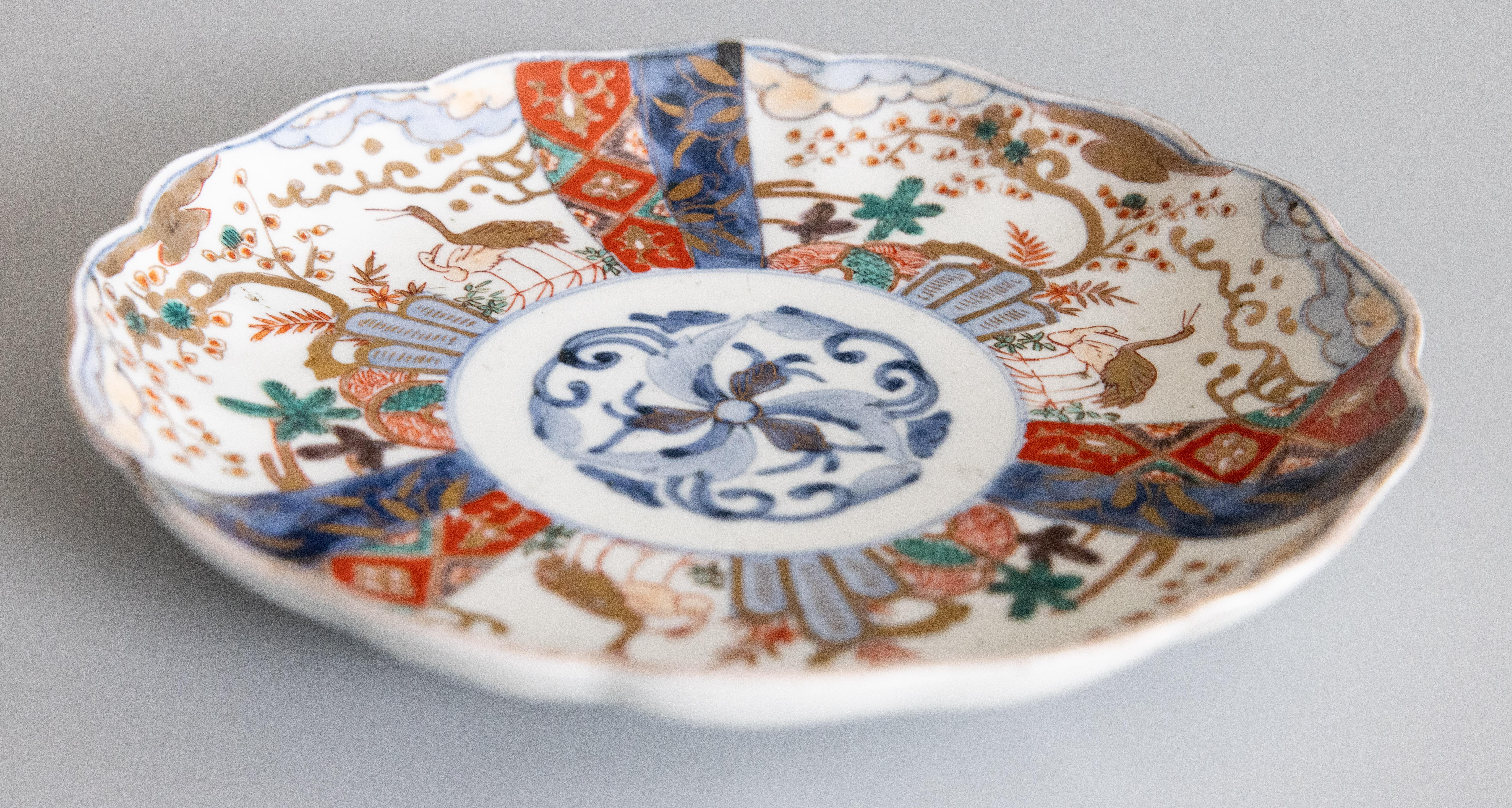 Une magnifique assiette Imari antique du 19ème siècle avec un bord festonné. Des oranges, des bleus et des verts éclatants sont à l'honneur. Le design multicolore représente des motifs japonais traditionnels, mettant en valeur l'artisanat complexe