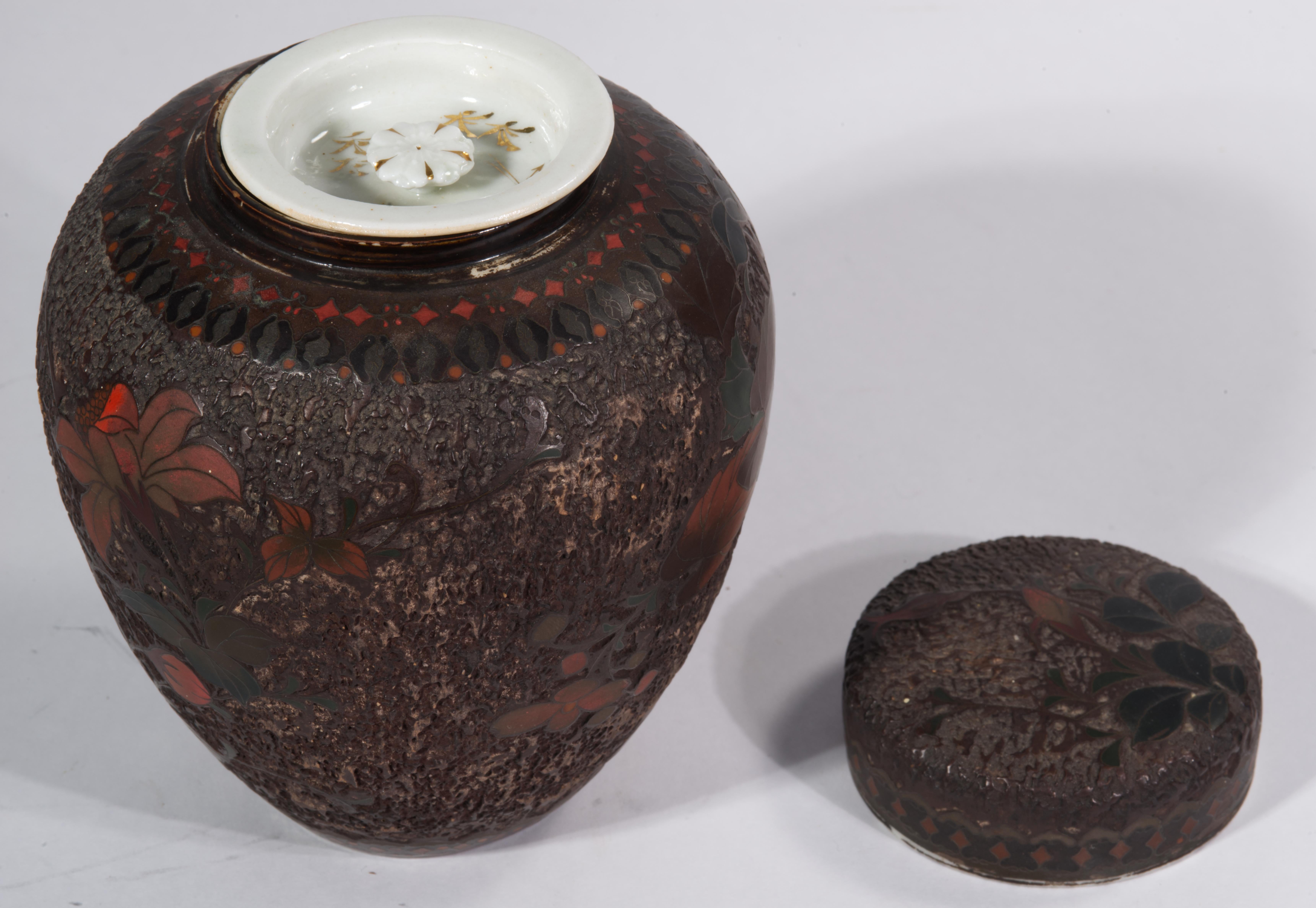Le pot à gingembre de taille moyenne ou le grand récipient à thé présente un décor détaillé d'un oiseau assis sur une branche fleurie, réalisé selon la technique Totai Shippo dans des couleurs rouge foncé et vert. L'épaule de la jarre est rehaussée