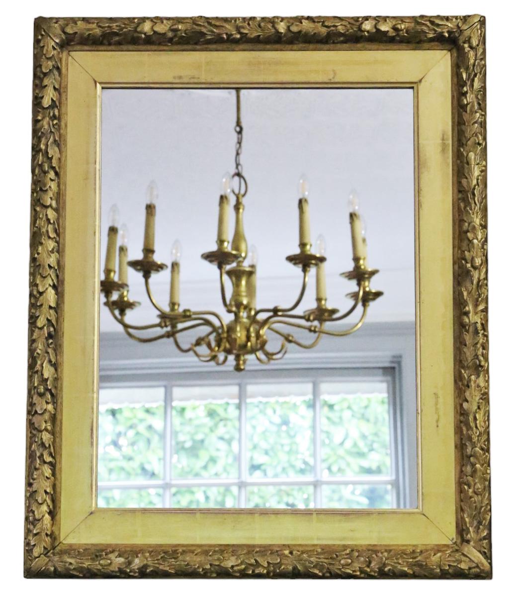 Antique 19th Century large gilt overmantle wall mirror of fine quality, adorned with a decorative oak leaf design.

This mirror captivates with its simple yet striking design, lending character to any suitable space. The frame is solid and free from