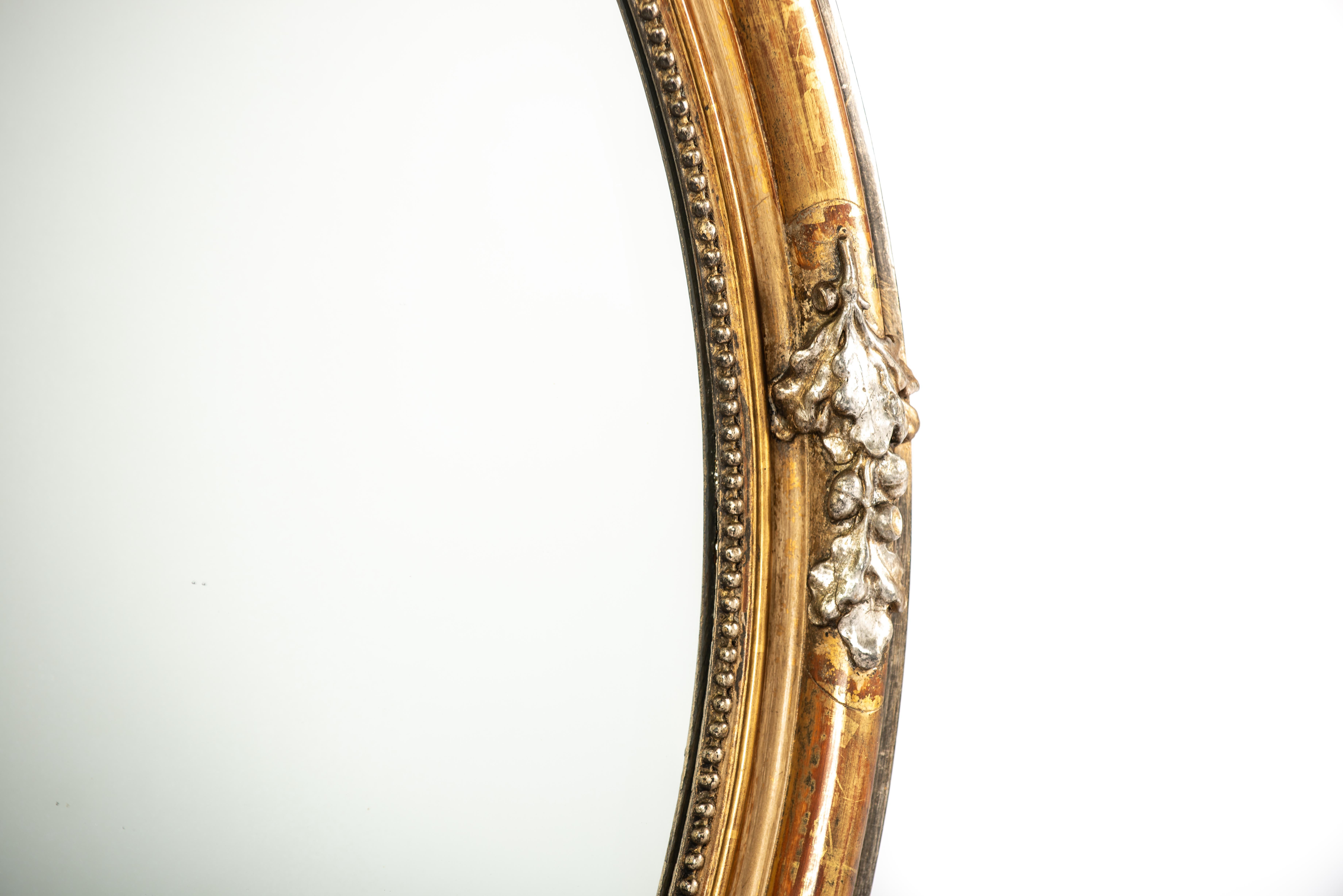 Empire Antique 19th century large oval gold and silver leaf gilt French mirror For Sale