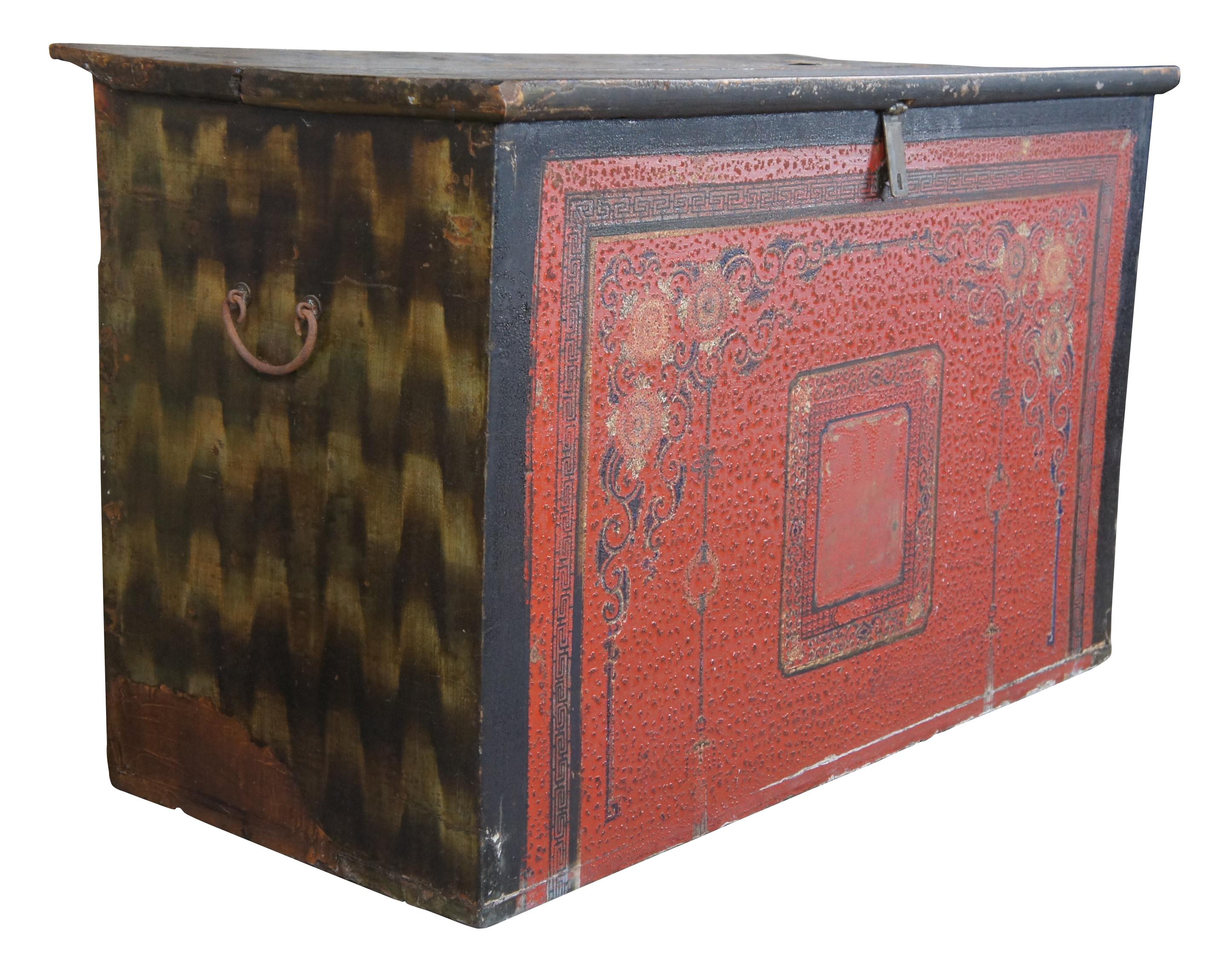 Monumental 19th century Tibetan blanket or storage chest. Rectangular in form with a hand painted red and black textured front with flowers, scrolls and Chinese Greek key design. Features a split top with removable lid, a black and gold zig zag