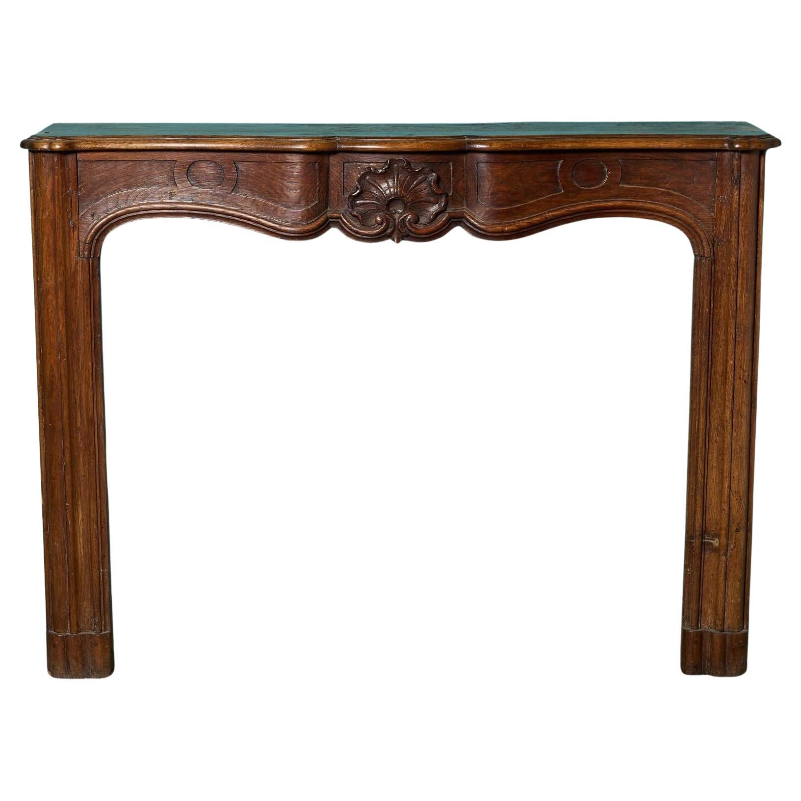 Cheminée ancienne Louis XV du 19ème siècle en chêne sculpté