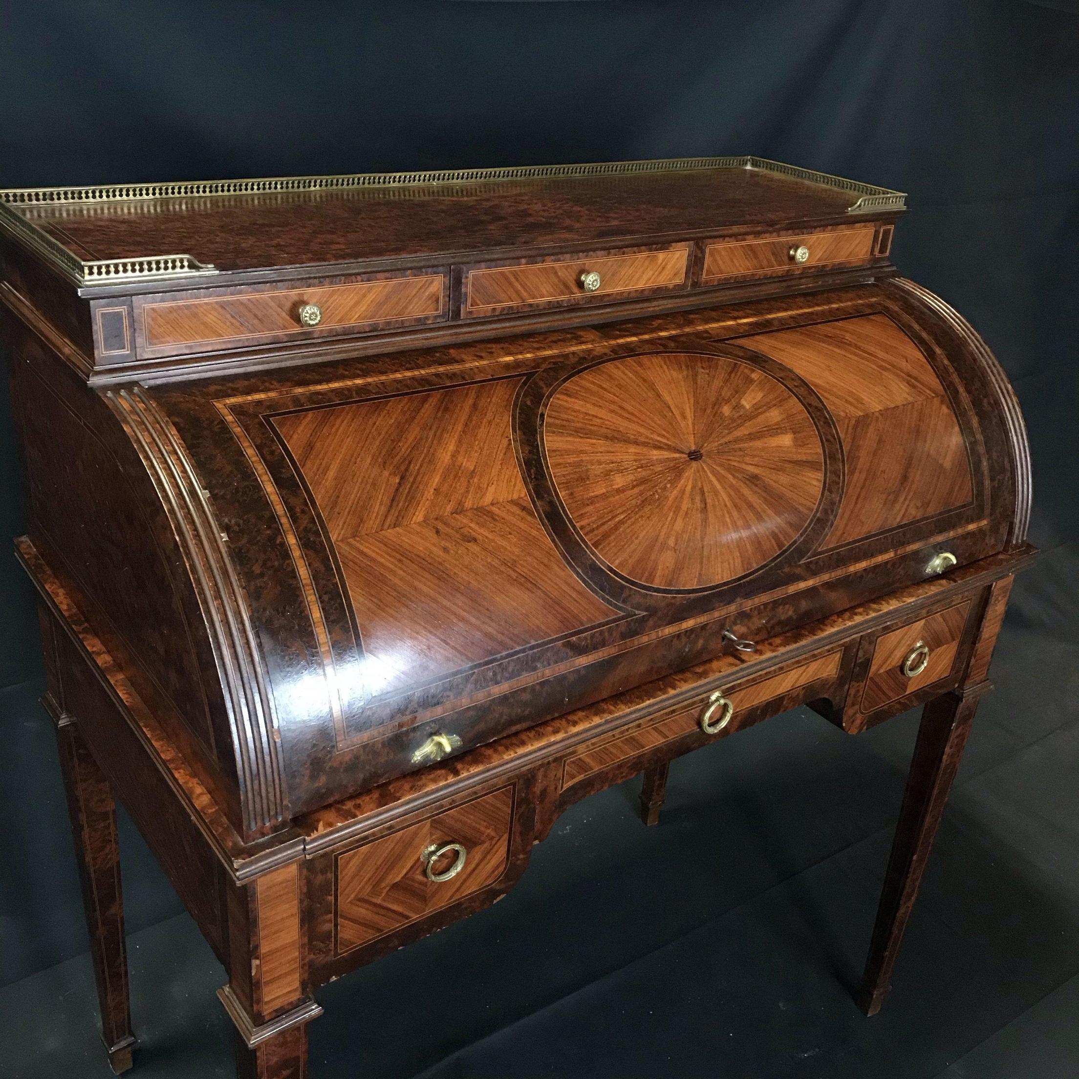 Very elegant Louis XVI style freestanding antique French cylinder writing desk veneered with walnut burled wood. The cylinder opens to reveal a pull-out writing surface and four drawers with space above for various items. Above the cylinder are