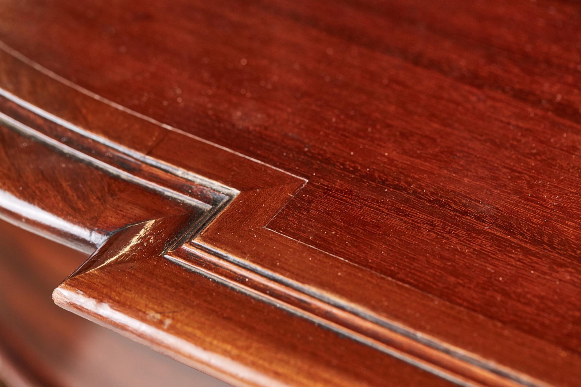 Libreria antica di qualità in mogano astragale smaltato con cornice a dentelli, frontone a collo di cigno e splendido terminale centrale intagliato. Il piano della libreria con quattro ante a vetri astragali racchiude ripiani regolabili. La base è a