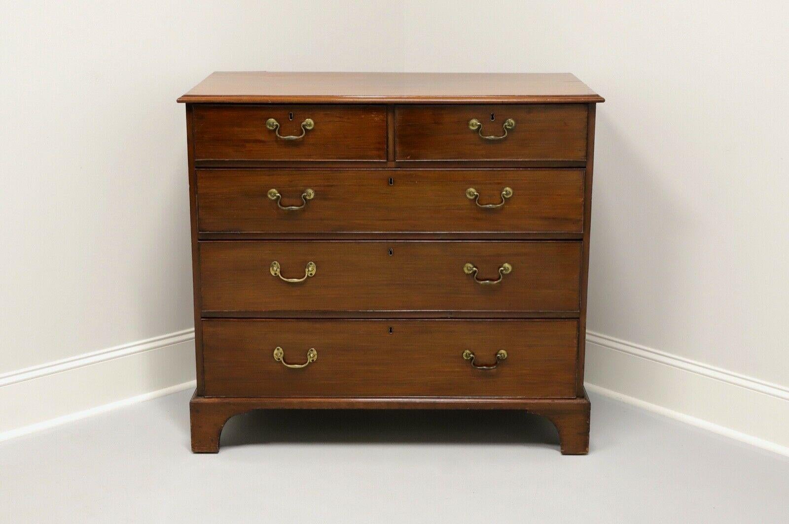 An antique Chippendale style chest of drawers, unbranded. Mahogany construction with brass hardware and bracket feet. Two smaller over three larger dovetail drawers with cockbead and brass hardware. No key for locks. Left side hardware on lower two