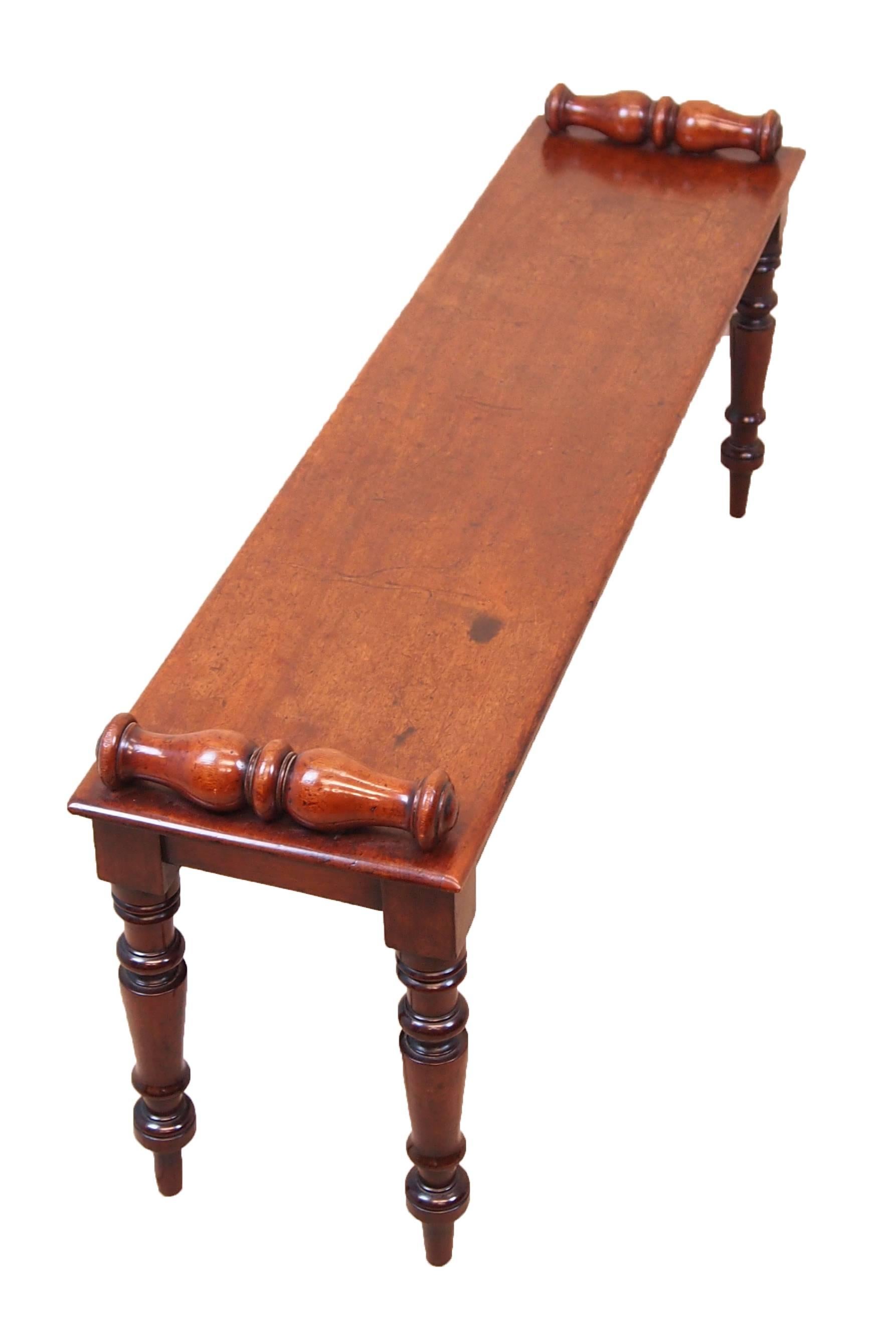 A good quality mid-19th century mahogany window seat hall
bench having well figured top with applied turned rolls to 
each end raised on elegant turned tapering legs.