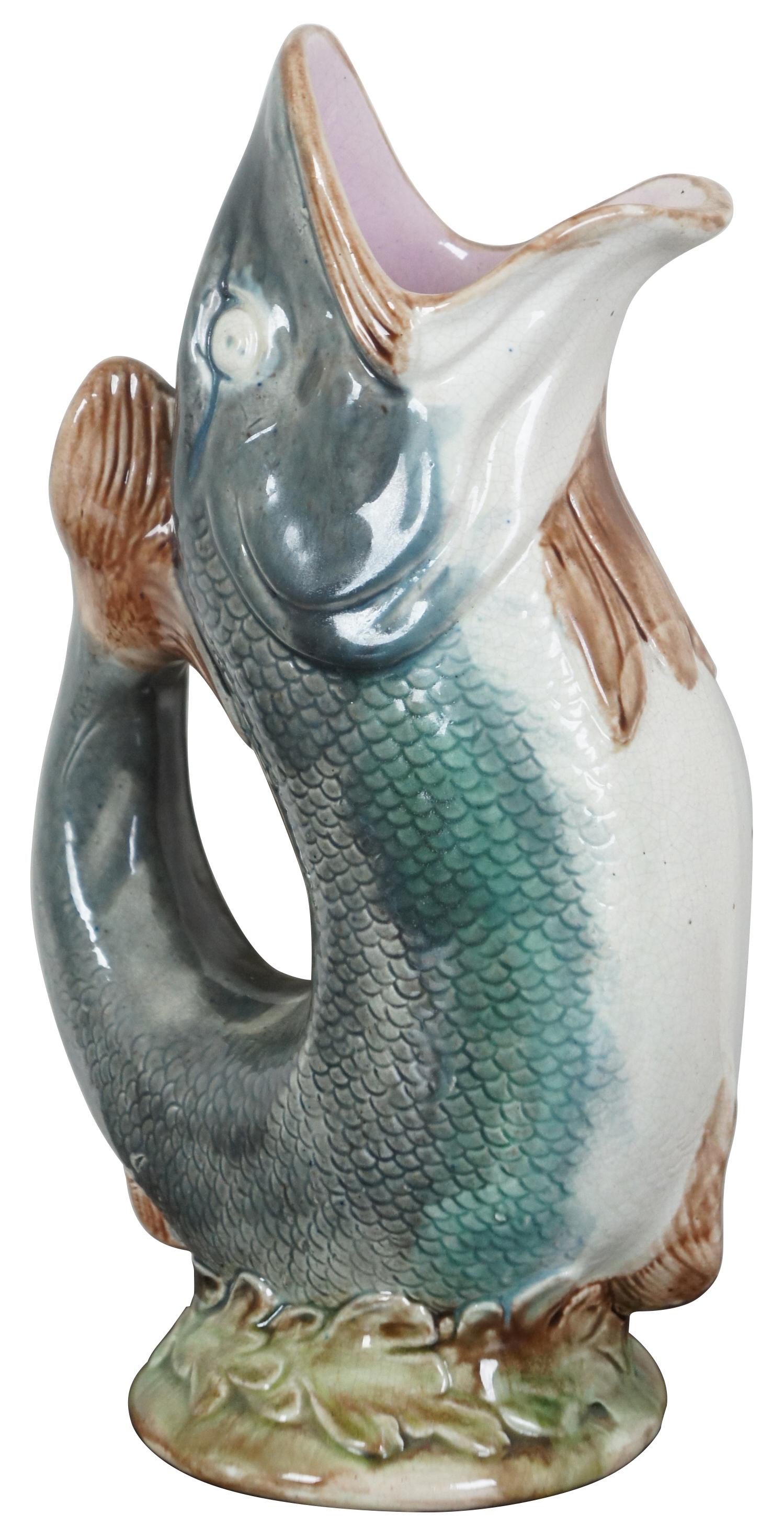 Antique Majolica porcelain vase shaped like a gray, green and white fish balanced upright on its tail. Gurgles when you pour. Measure: 11'.