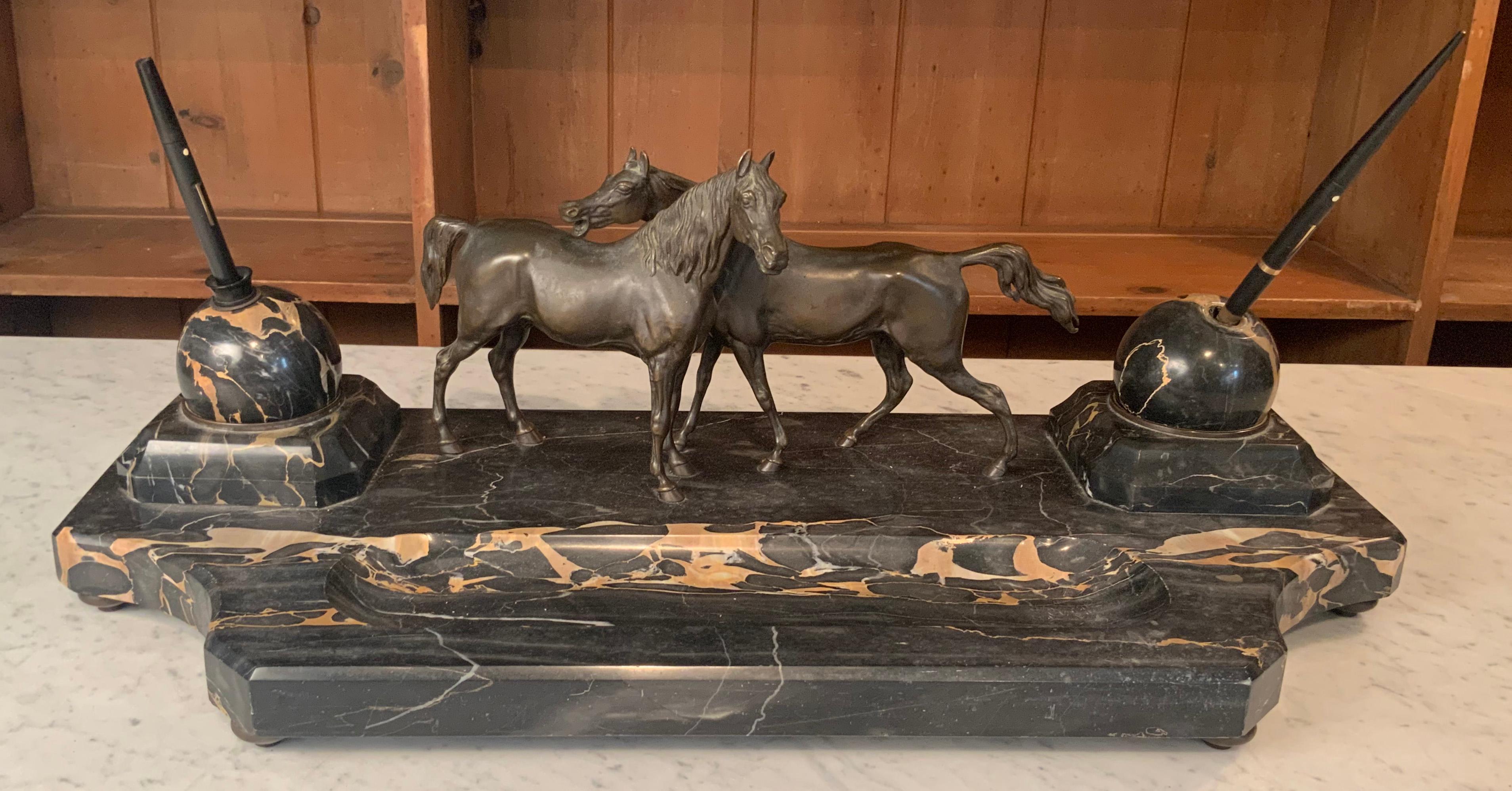 A very handsome antique 19th century desk set, in black marble with ivory colored veining, and a pair of ball shaped floating inkwells. The center of the marble stand mounted with a pair of bronze horses. And also included is the companion marble