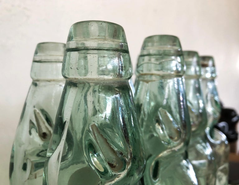 This set of 6 rare antique 19th century Mexican codd neck glass soda bottles are an incredibly special and unique rare set to add to your collection. Made of heavyweight transparent light green and aqua blue glass. The bottle is pinched into a