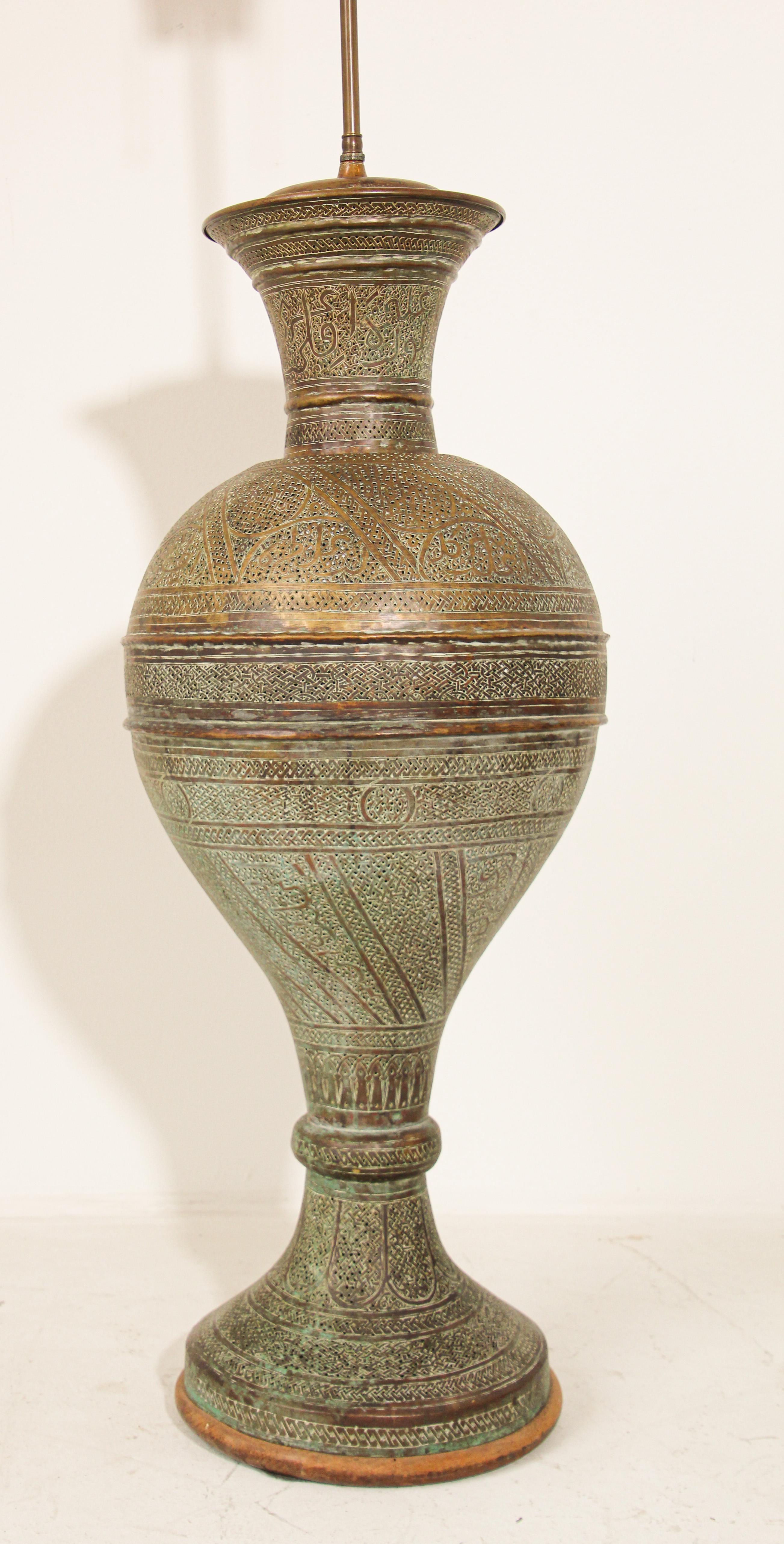 Elegant antique Oriental Middle Eastern hand-etched and pierced finely engraved patinated floor lamp.
Intricate Indo-Persian decoration on the tall brass urn with a trumpet style neck mounted on an wood base.
Extremely fine antique 19th century