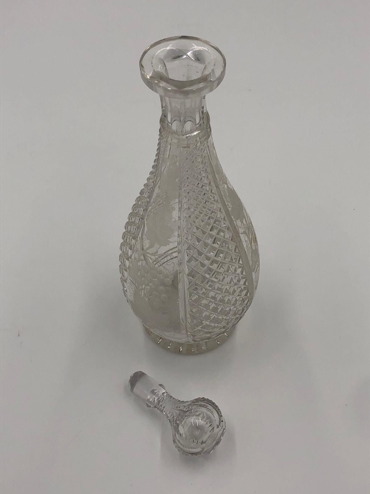 Ancienne carafe en verre taillé du 19e siècle de l'époque victorienne, le corps de la carafe alternant entre le verre taillé et les feuilles de vigne, avec le bouchon d'origine.

Très petit manque à la base du bouchon comme montré dans la dernière