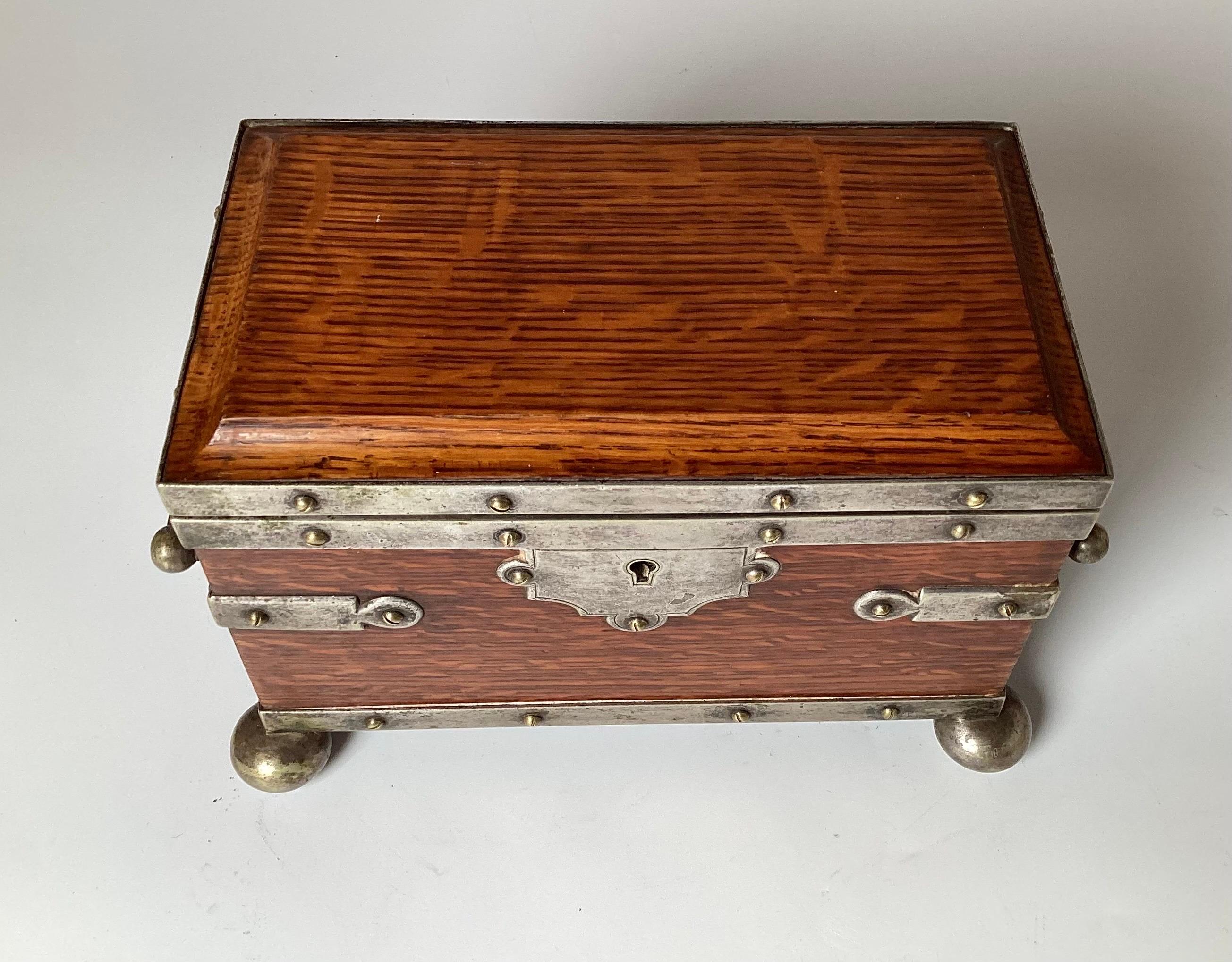 Mid 19th century English silver-plate and solid oak two handled tea caddy. The interior with two compartments with the foil lining replaced. With original key.