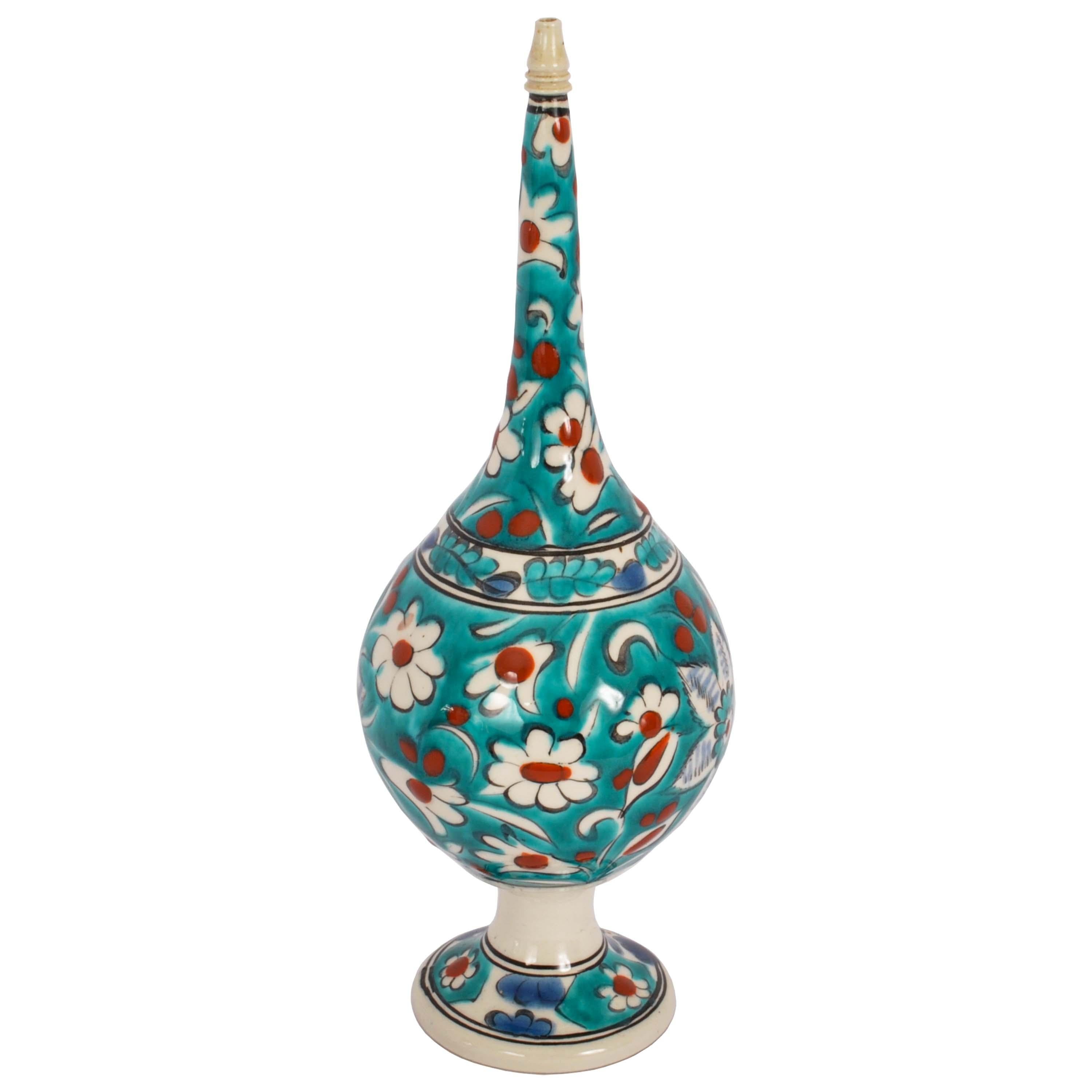 A good antique Islamic Ottoman Kutahya pottery rosewater dropper, Turkey, circa 1900.
The rosewater dropper of globular form with a tall tapering neck and raised on a flared foot, decorated with vibrant floral decoration on a turquoise