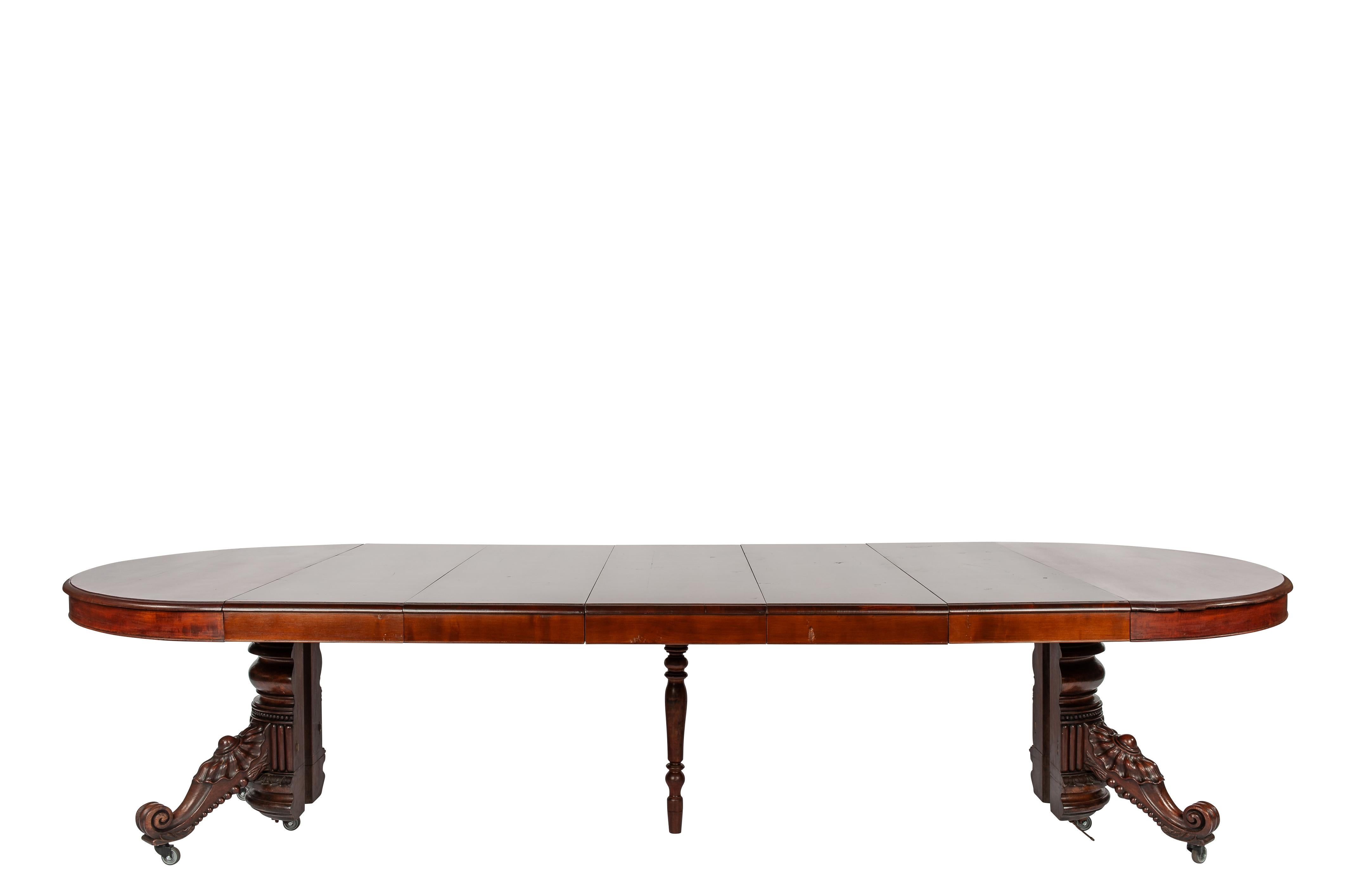 Carved Antique 19th-century oval extendible French warm brown mahogany dining table. For Sale