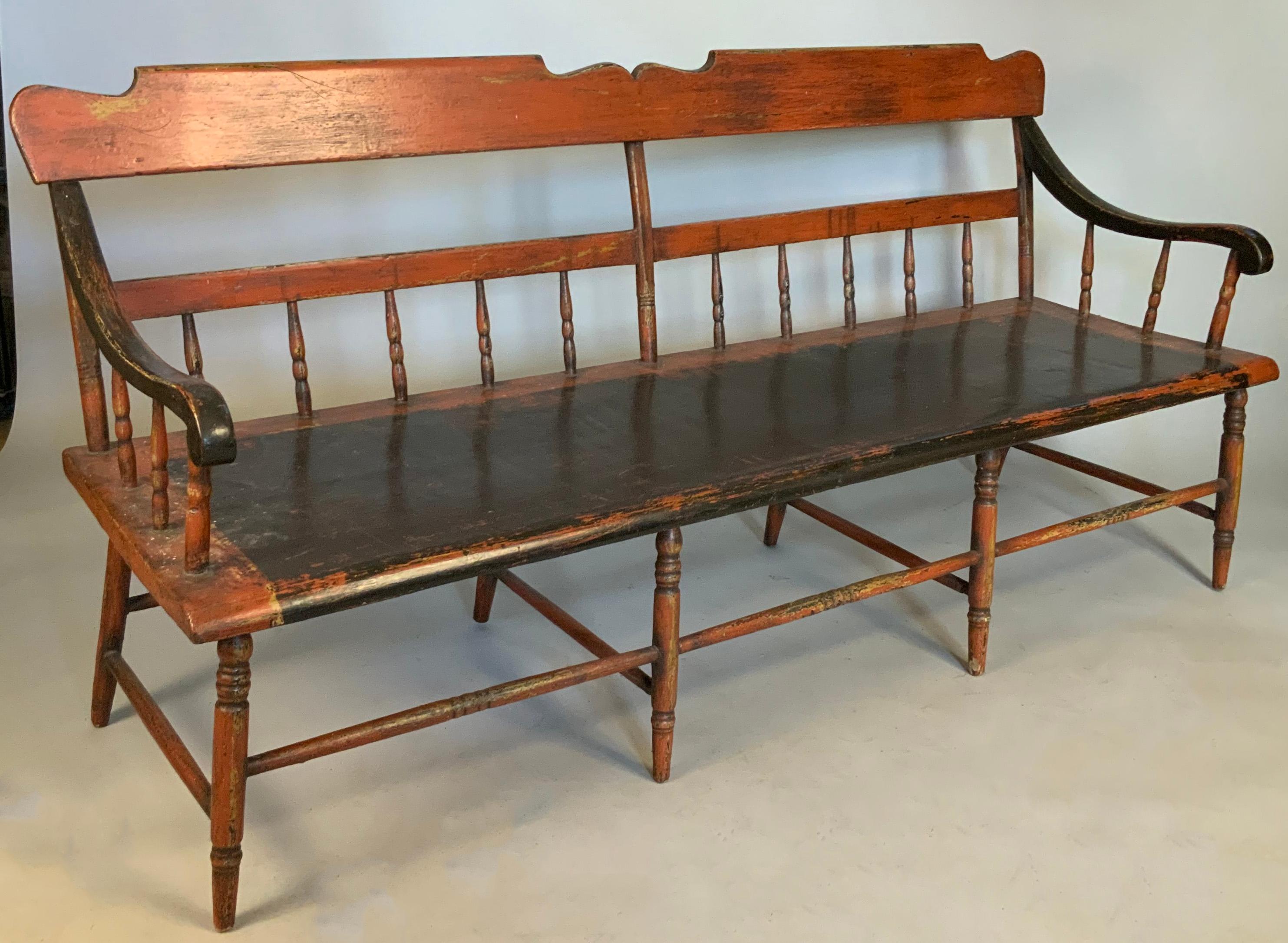 A very beautiful and large antique late 19th century painted country bench, with spindle back and gently curved and sculpted armrests. The seat is wide and deep, and the whole piece retains most of its original painted surface.