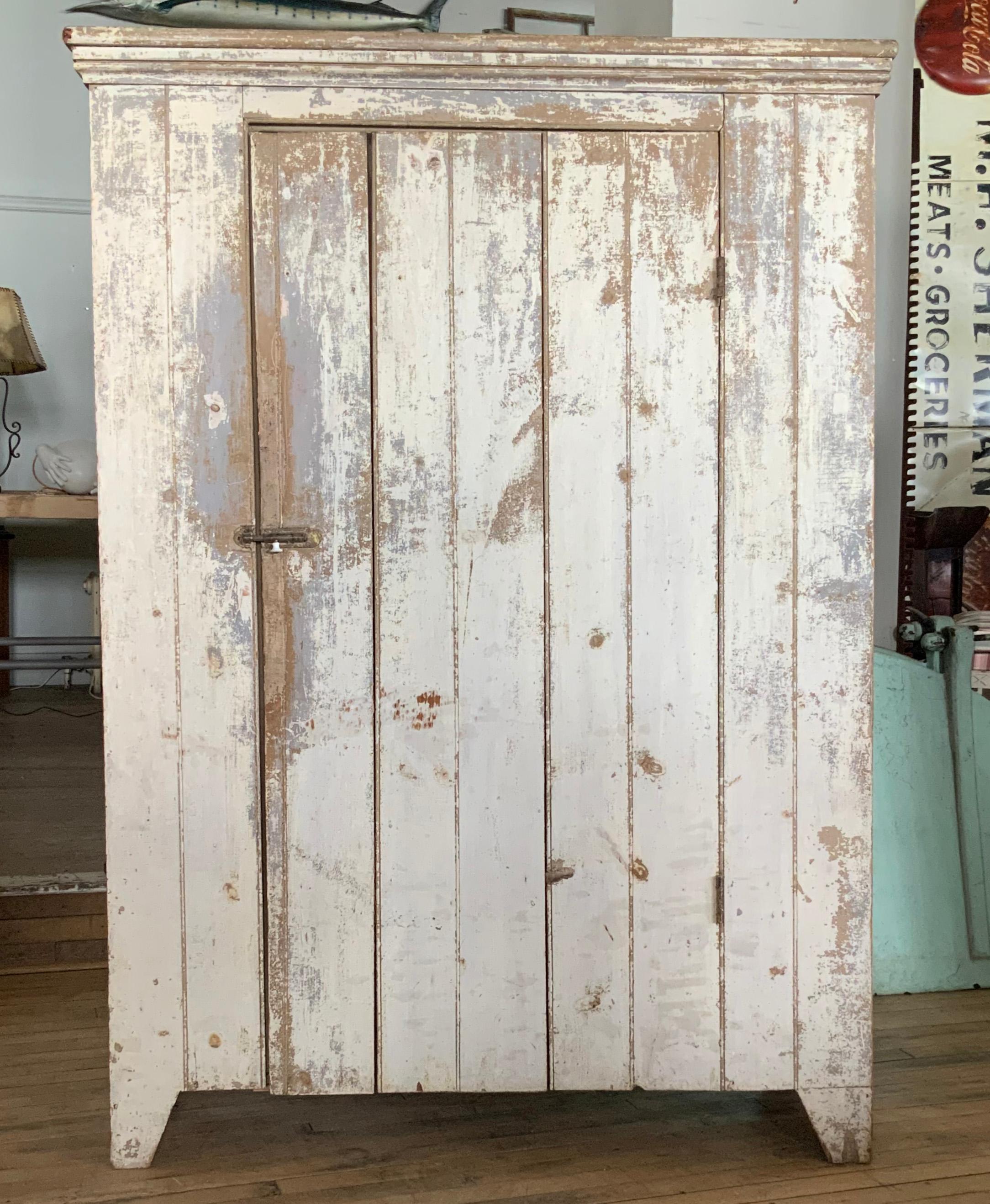 A beautiful antique late 19th century painted cupboard, with a large single door and three interior shelves. Beautiful original ivory painted finish is worn in a very nice way. Great scale and proportions.