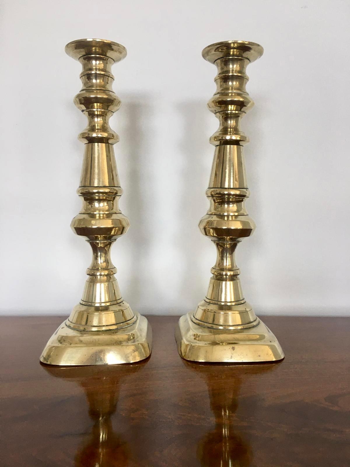 Pair of extra tall antique brass candlesticks with a lovely shaped column rising from a shaped stepped base, each still retaining their original push ejector rod.

In lovely original condition.

Measures: H 30.5cm
W 12cm
D 10.5cm.
 