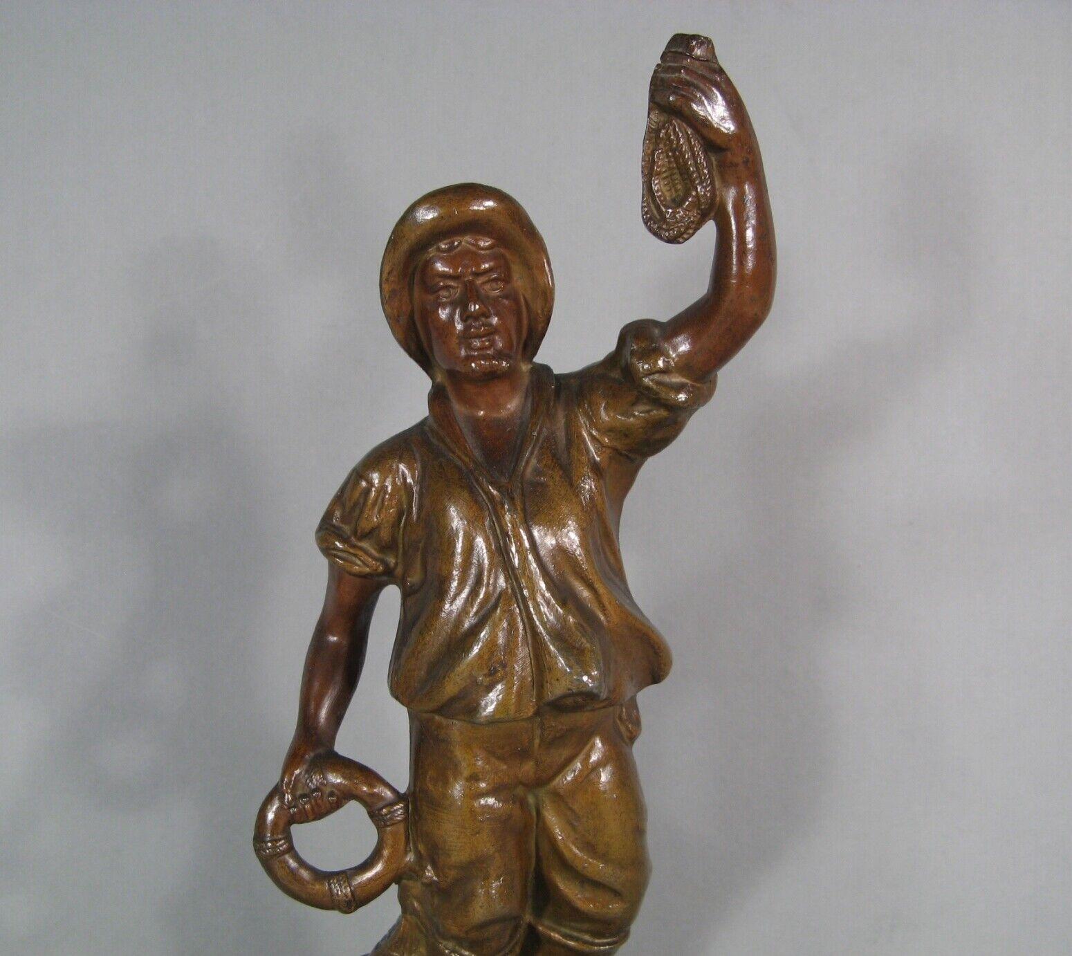 Add a piece of maritime history to your collection with this antique 19th-century sculpture of a sea rescuer, crafted from patinated spelter. This striking figurine, dating from the early 20th century, is mounted on a wooden base designed to mimic