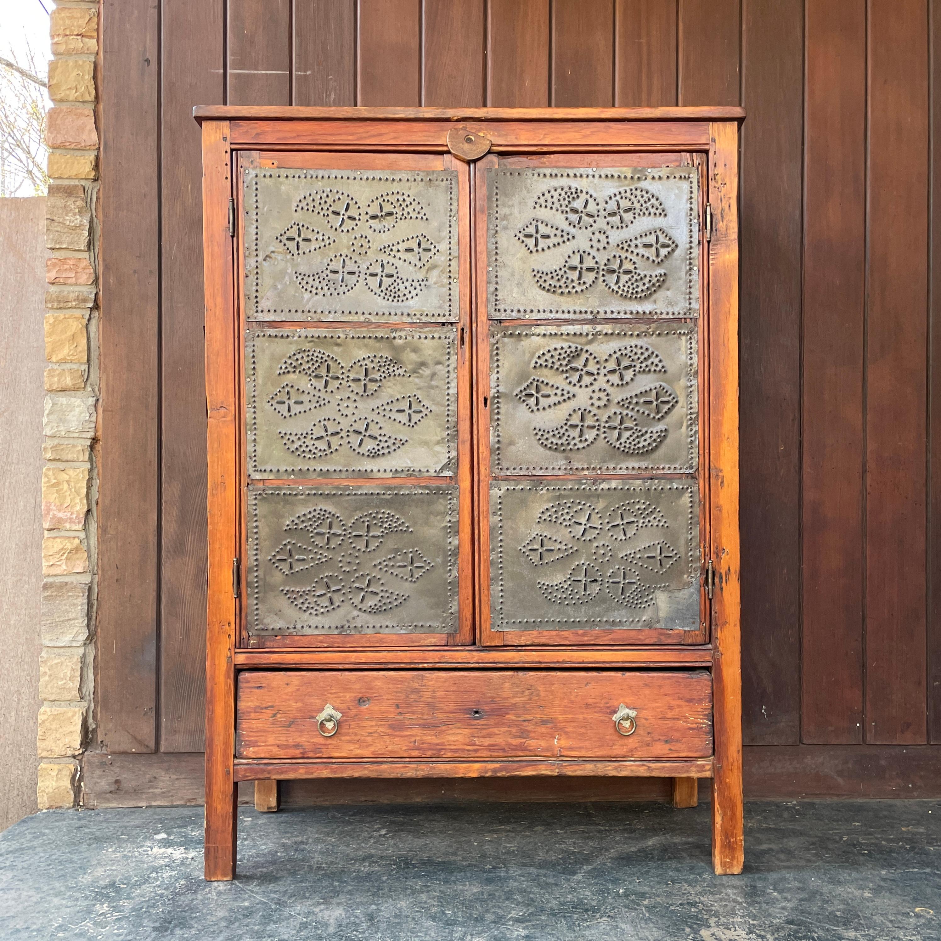 Very old antique cabinet. Square nails! Tin seems poorly done, and possbily a more recent marriage, it is also patched to the bottom right corner.  Procured from a collectors estate, we have no additional information on this item.

W 36 7/8 x D 15