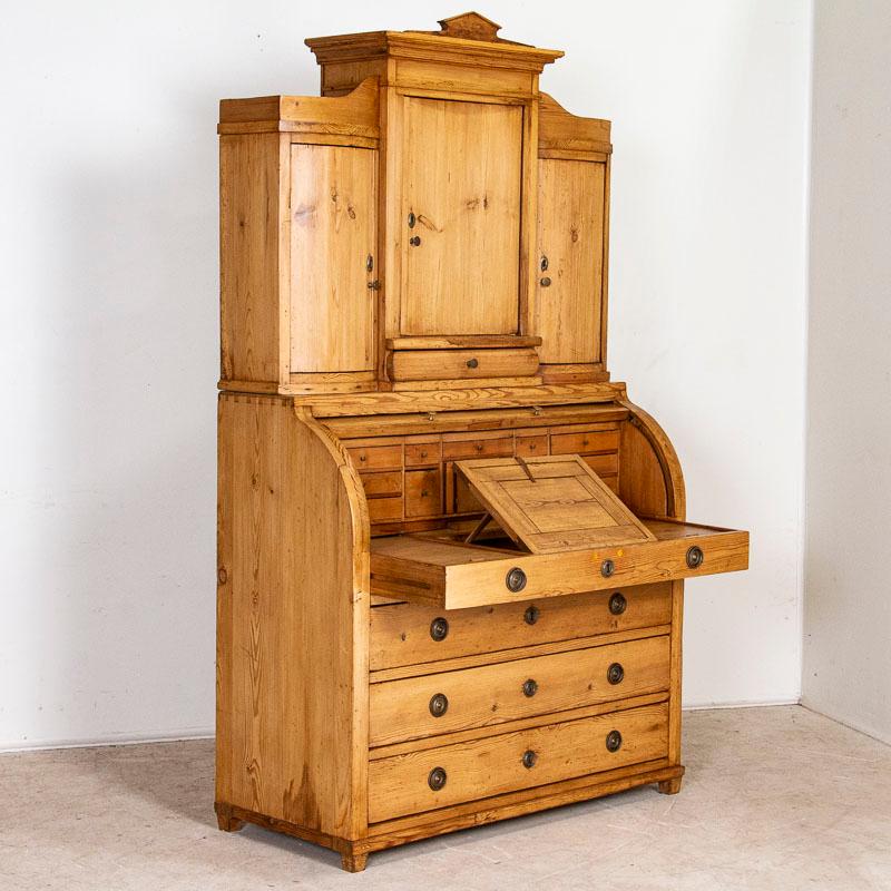 This truly lovely mid 19th century secretary becomes a showcase thanks to the beauty of the natural pine, waxed to bring out the warmth of the wood and attractive concave doors. There are countless drawers for organization, including a hidden