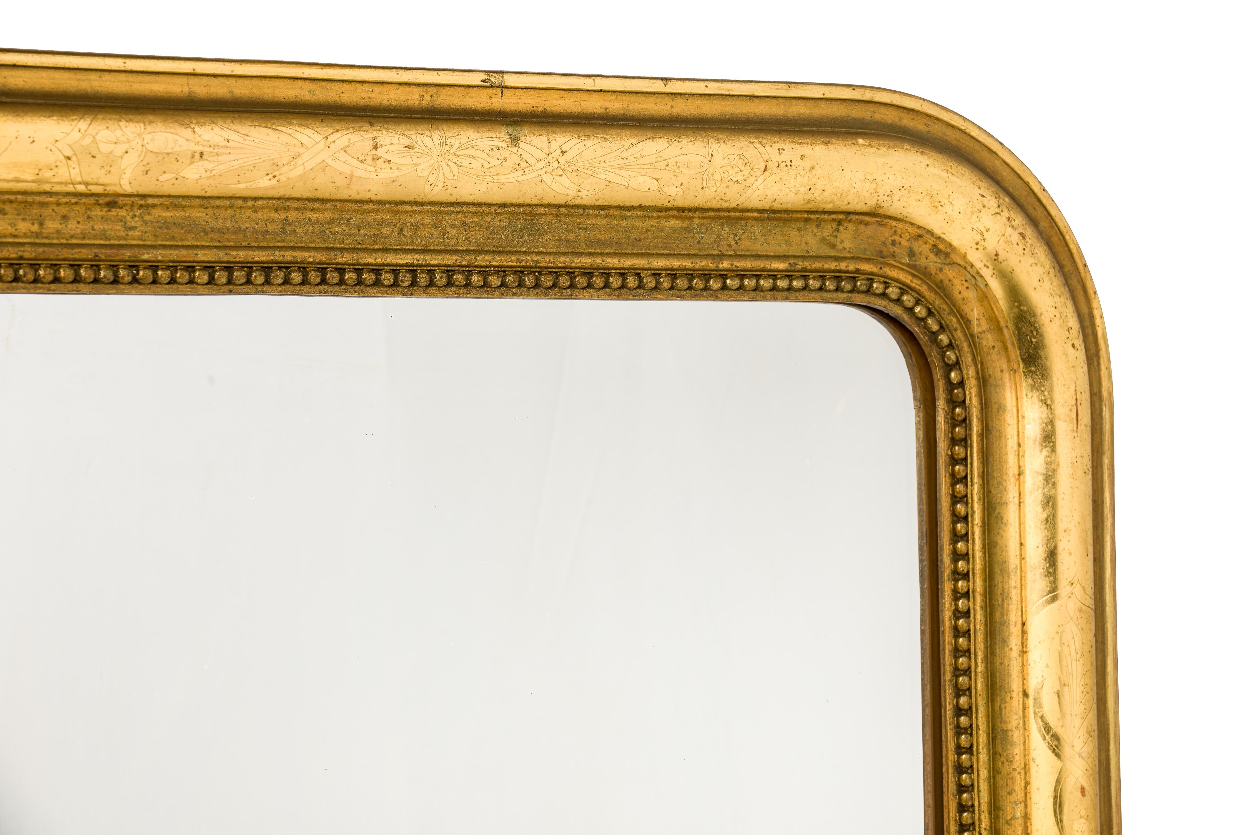 This beautiful Louis Philippe mirror was made in France, circa 1870. The mirror has a solid pine frame smoothened with gesso. The upper rounded corners are typical for the French Louis Philippe style. The authentic glass is surrounded by a classic