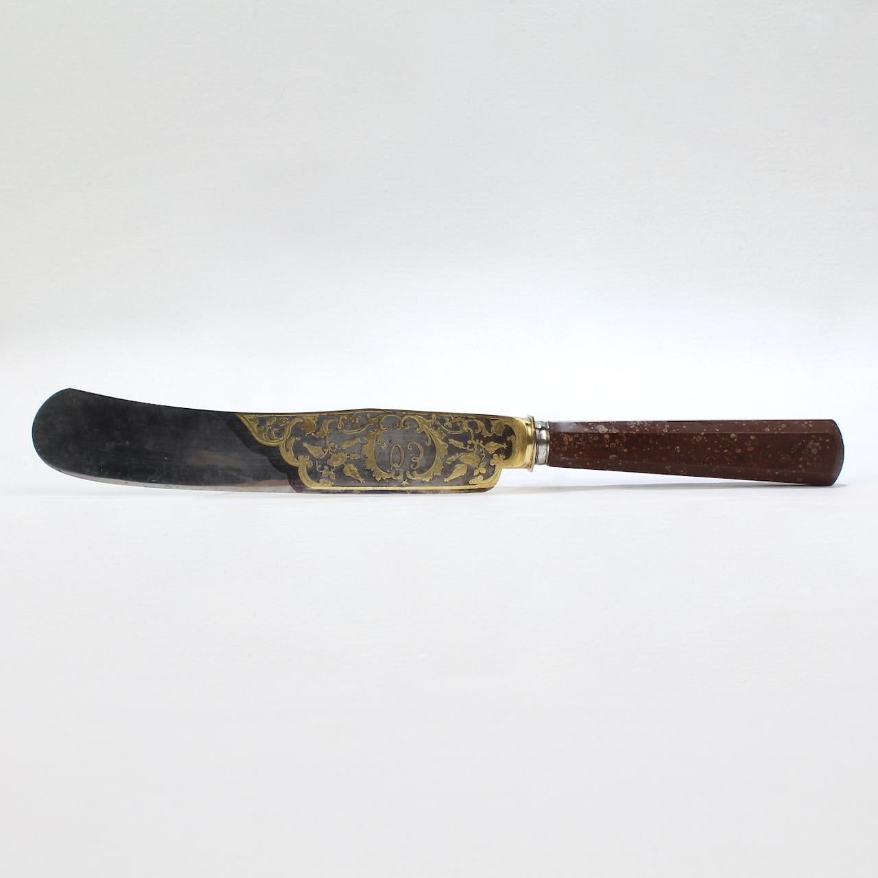 Offered here for your consideration is a very fine antique porphyry handled knife.

With a silver-plated steel knife blade set in a chamfered porphyry handle.

The blade has an acid etched and gilded hunt scene decoration on one side and a cartouche