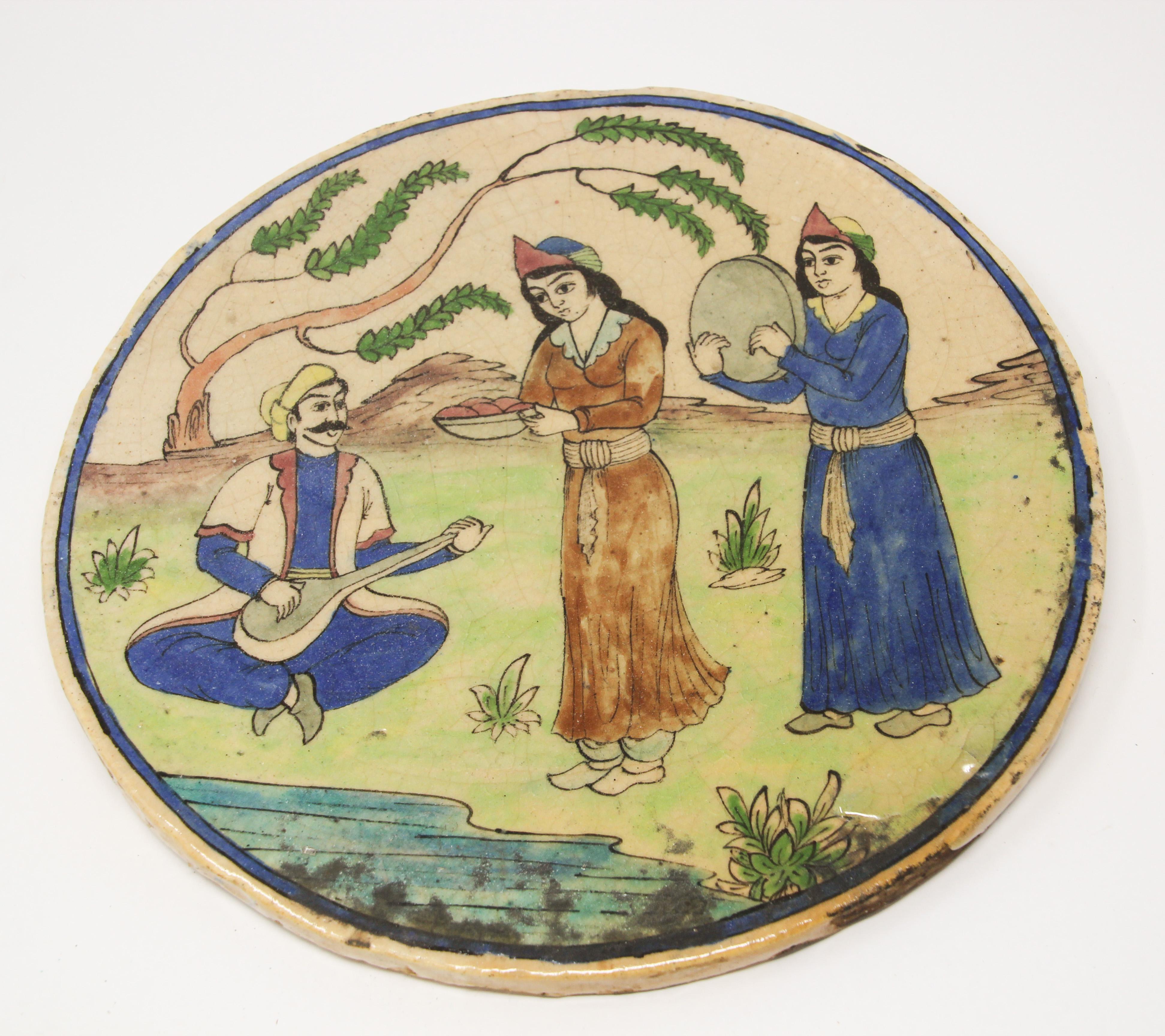 Antique Qajar Middle Eastern Islamic tile plaque.
Moorish glazed ceramic tile depicting an outdoor scene with musician and women serving food and dancing.
Beautiful Moorish Turkish handcrafted decorative circular crackle hand painted and glazed