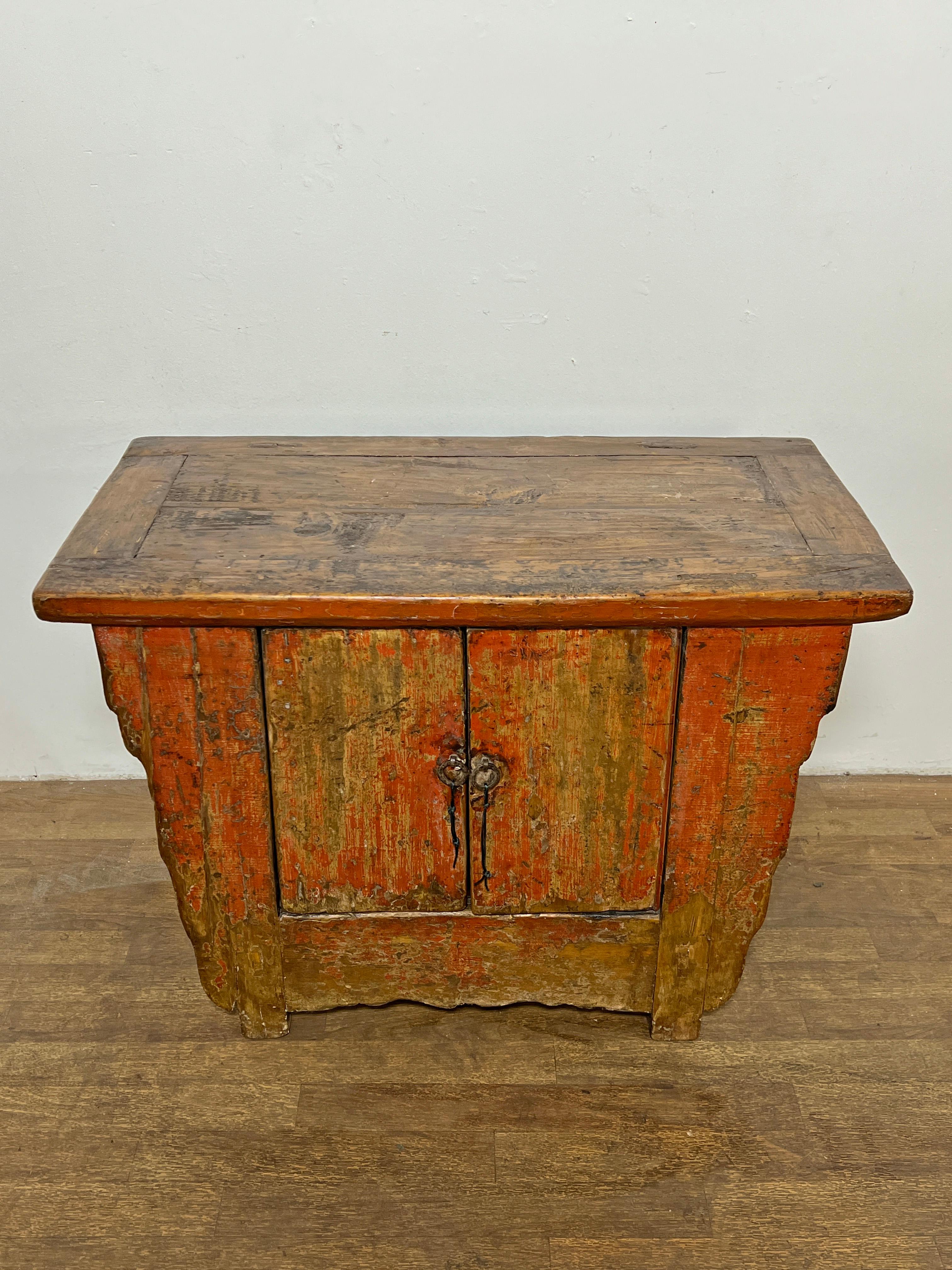 A 19th century Qing Dynasty cabinet in carved elm with traces of original beetle red lacquer from Gansu Province.