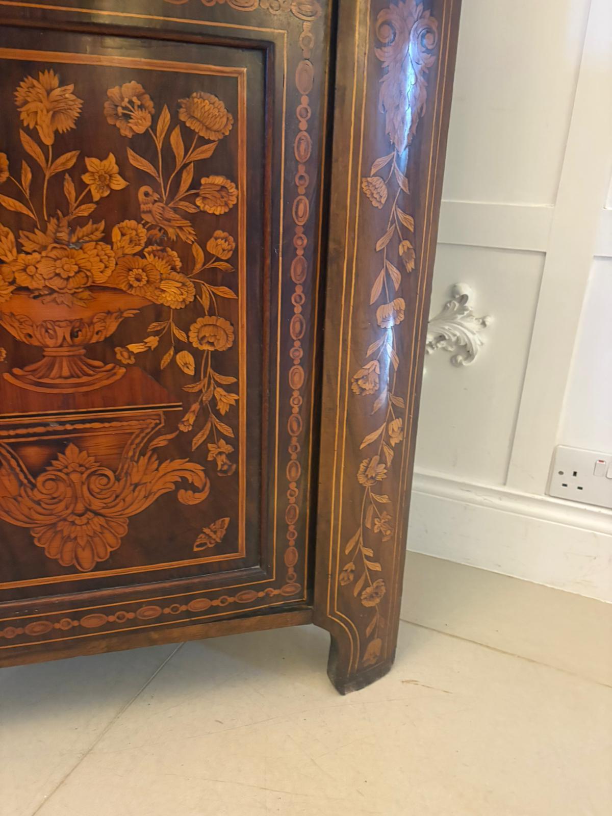 Superbe vitrine ancienne présentant une marqueterie exquise et des incrustations florales, datant de la fin du... Fabriquée en acajou riche avec des placages contrastés de bois satiné et de bois fruitier, cette pièce met magnifiquement en valeur
