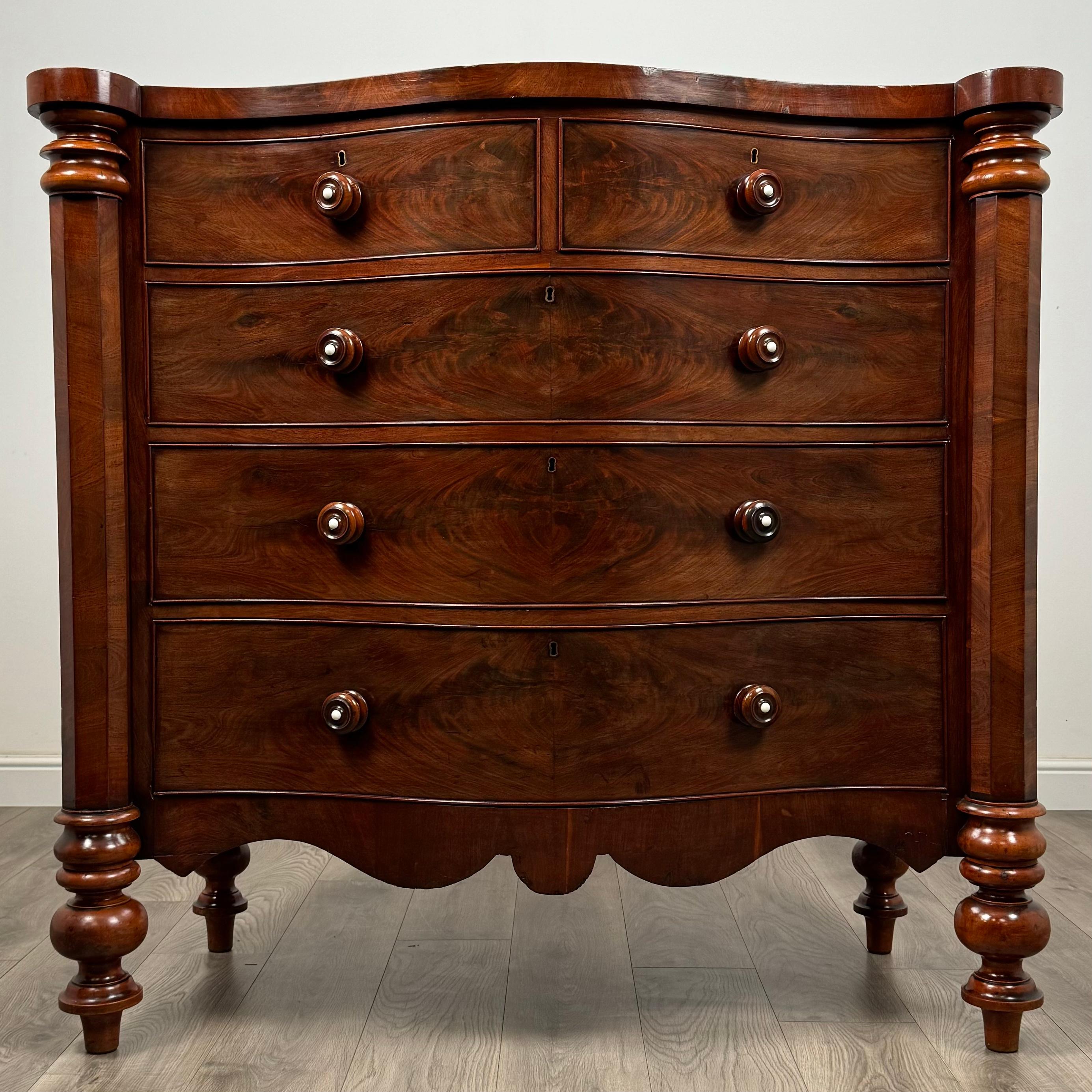 Ti presentiamo una rara ed eccezionale cassettiera antica a serpentina del XIX secolo, realizzata in mogano pregiato. Questo pezzo unico si distingue per il suo design mozzafiato, caratterizzato da grandi dimensioni e da un frontale splendidamente