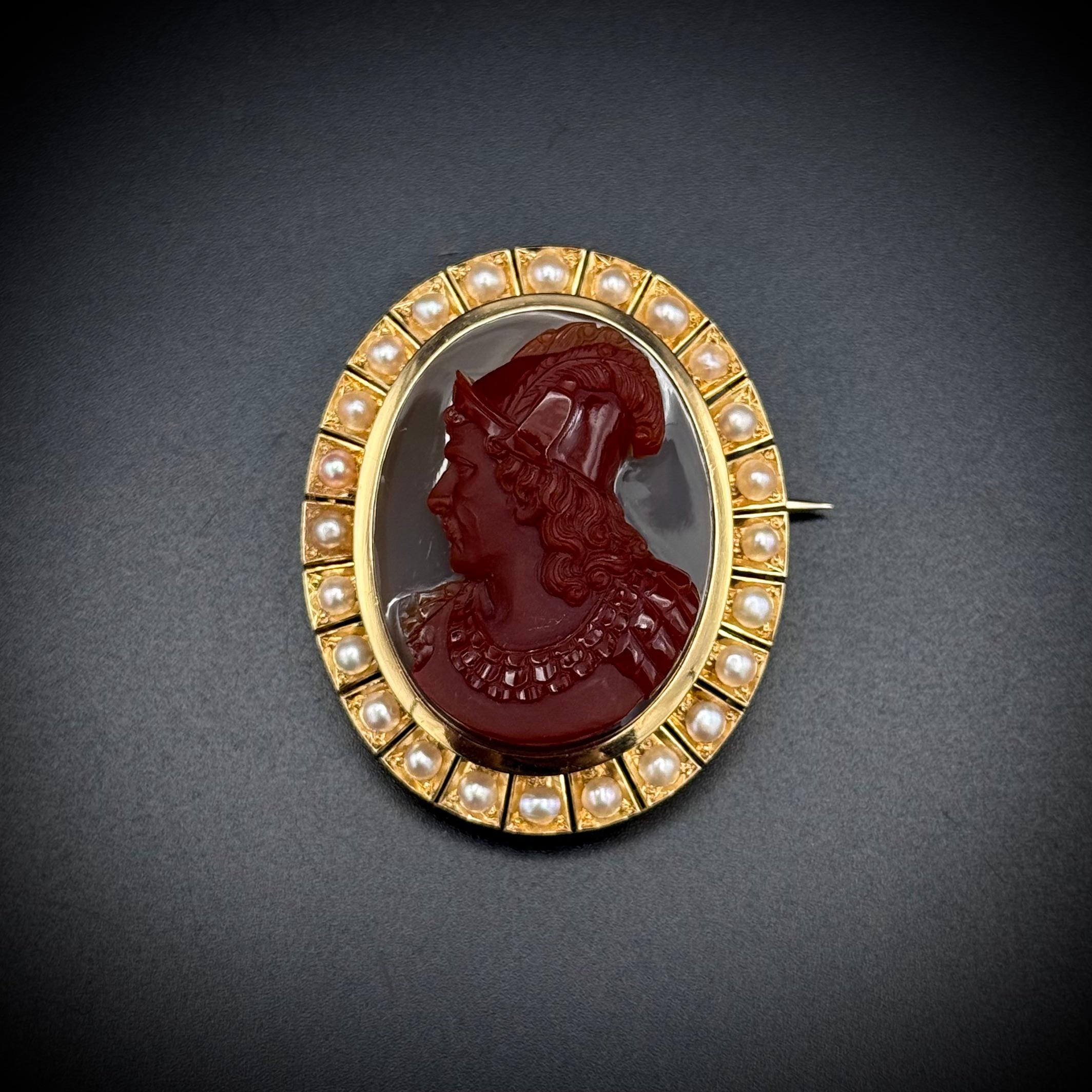 Antique 19th Century Sardonyx Cameo Brooch with Natural Pearls in Yellow Gold. A distinguished 19th-century cameo brooch featuring the intricately carved bust of a nobleman, executed in dark brownish-red sardonyx over a white background. The cameo
