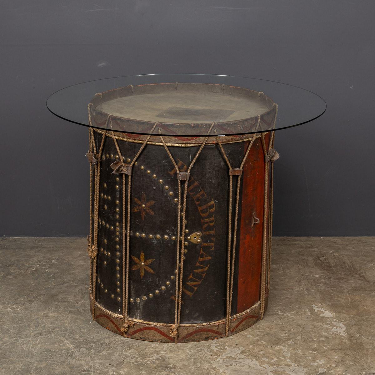 Antike große Regency-Militärtrommel aus dem 19. Jahrhundert, datiert um das Jahr 1820. Die Trommel ist aus Holz gefertigt, mit Messingbeschlägen versehen und mit den Insignien der Rule Britannia bemalt. Die Platte ist mit einer großen Glasscheibe