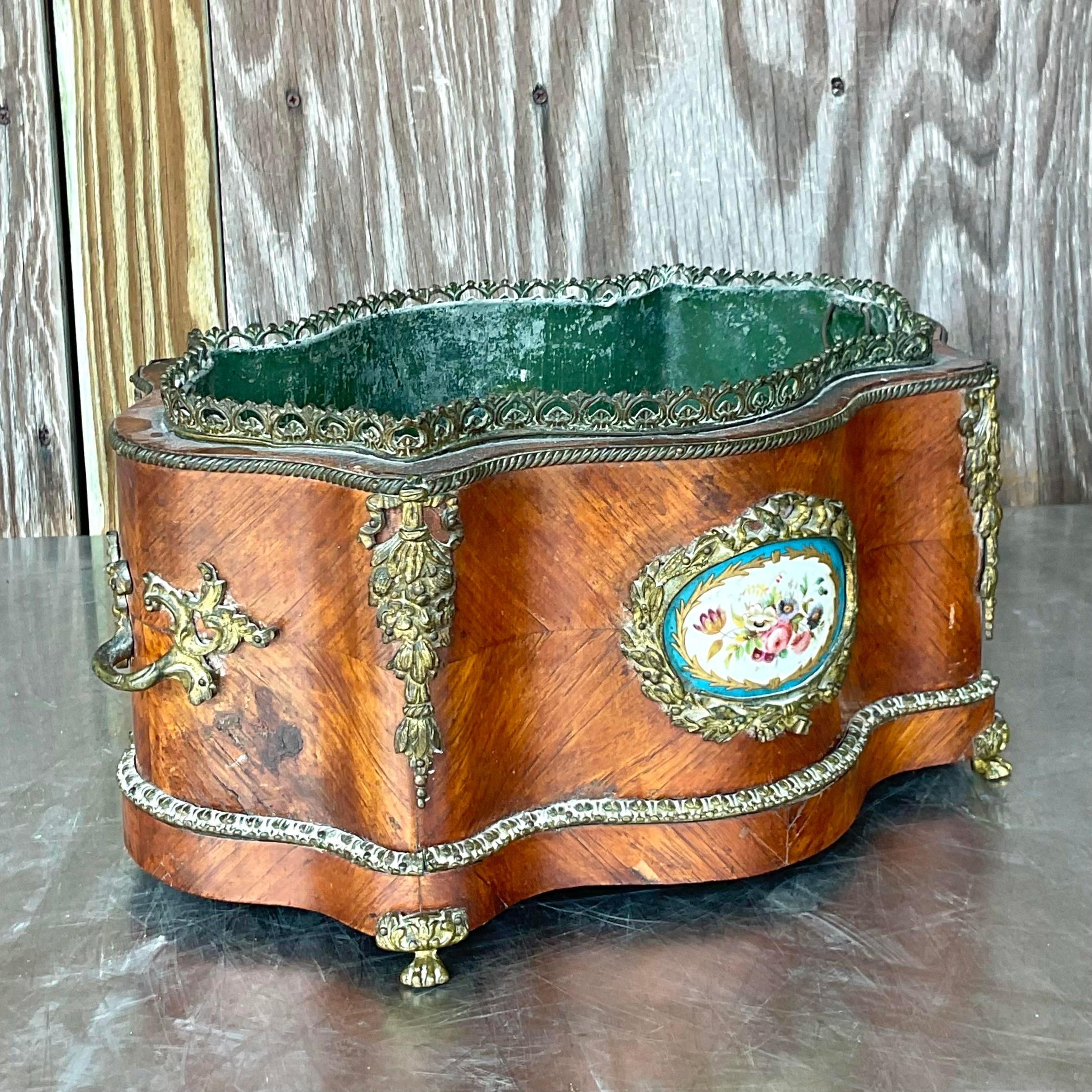 Capture the elegance of a bygone era with this Vintage 19th Century Regency Ormolu and Porcelain Planter. Infused with American style and refined craftsmanship, it's a timeless accent piece that adds sophistication and charm to any living space,