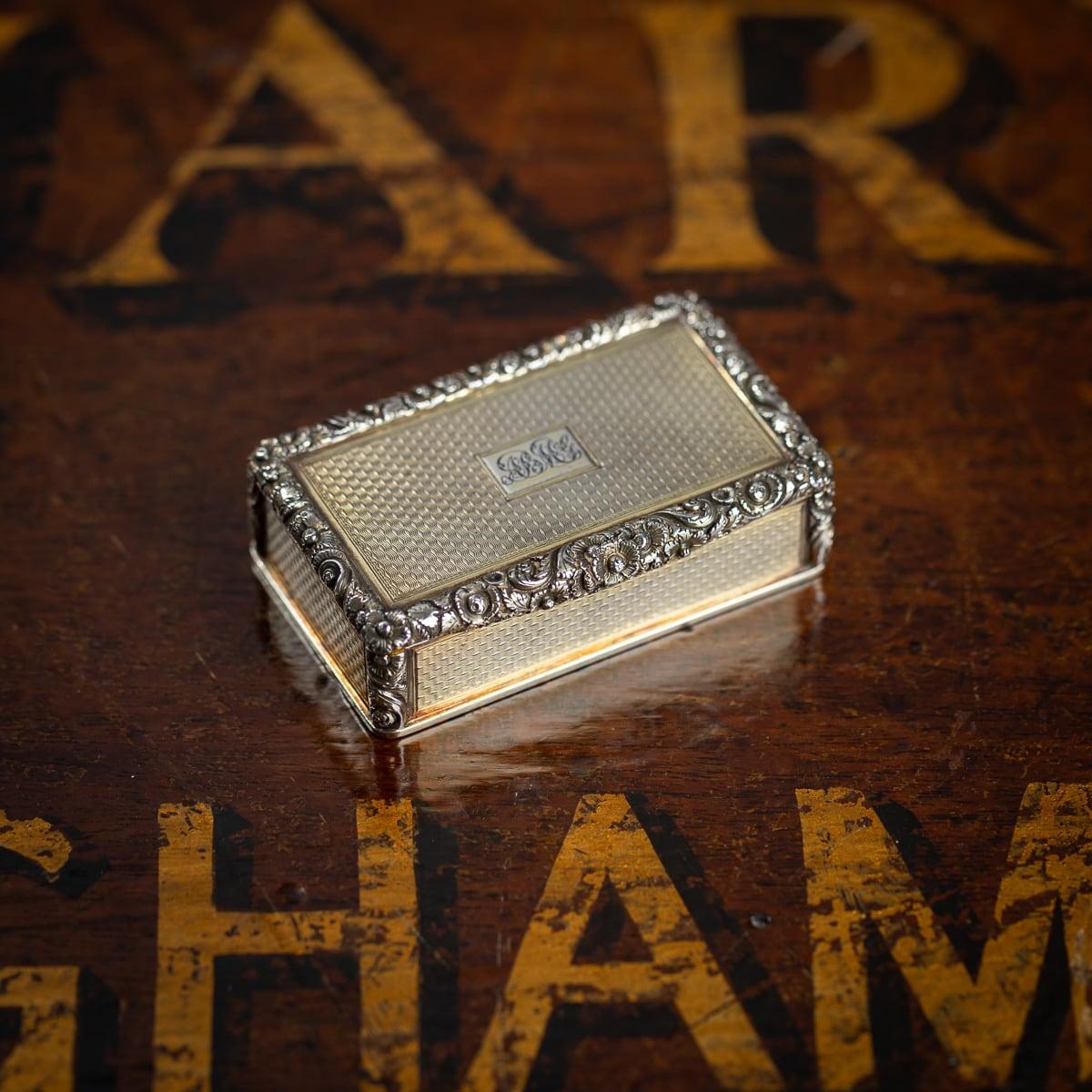 Antique 19th Century Regency solid silver-gilt snuff box, of rectangular form, the corners are beautifully chased with a floral decoration in relief, scroll thumb-piece, the lid, sides and base are engine-turned, richly gilt throughout. The cover