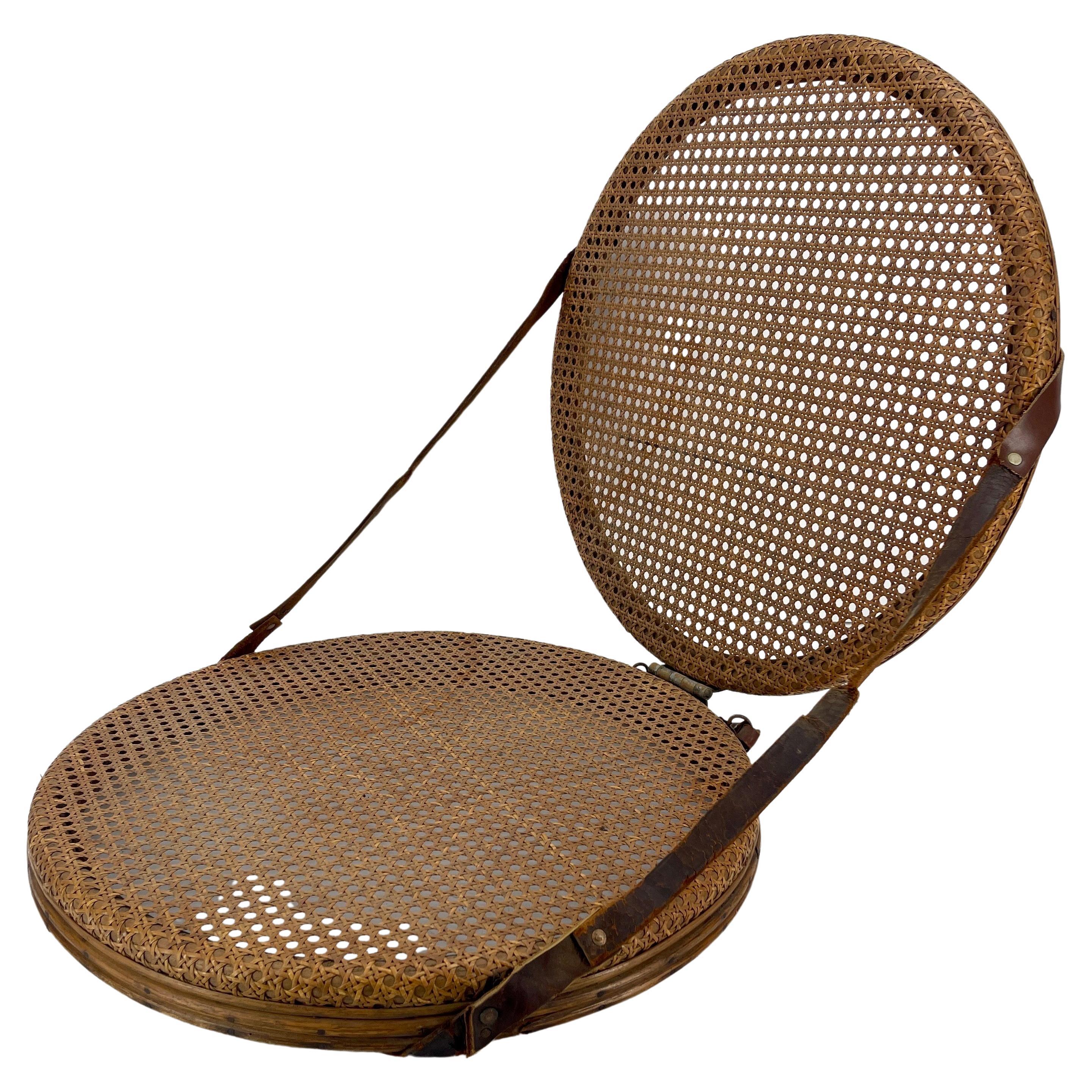 Classic American Portable Ruth Collins Round Beach Cane Backrest Seat, New York

Vintage folding picnic seat with original leather straps. The canning on this collasible piece is fully intact. Charming conversation piece. Marked with metal tag