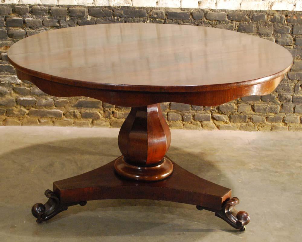A beautiful round mahogany dining table on a trefoil platform base that ends in elegant handcarved scrolls.
The base supports an octagonal baluster in mahogany veneer. The table top is made with mahogany veneer in “livre ouvert” style.
It is made