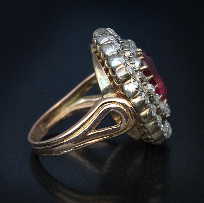 Circa 1860

This Victorian era cluster ring is handcrafted in 14K rose gold and silver. The ring features a cushion shape rubellite of a rich pink color with reddish and purplish tones. The center stone is framed by two rows of chunky old rose cut