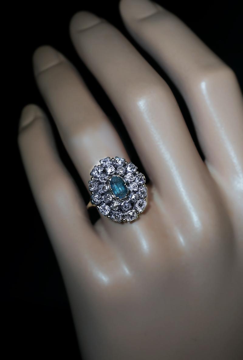 Circa 1870

This antique Victorian era cluster ring is finely crafted in 14K gold and silver. The ring is centered with a rare Russian Alexandrite (6.55 x 3.99 x 3.50 mm, approximately 0.75 ct), surrounded by two rows of chunky old mine cut