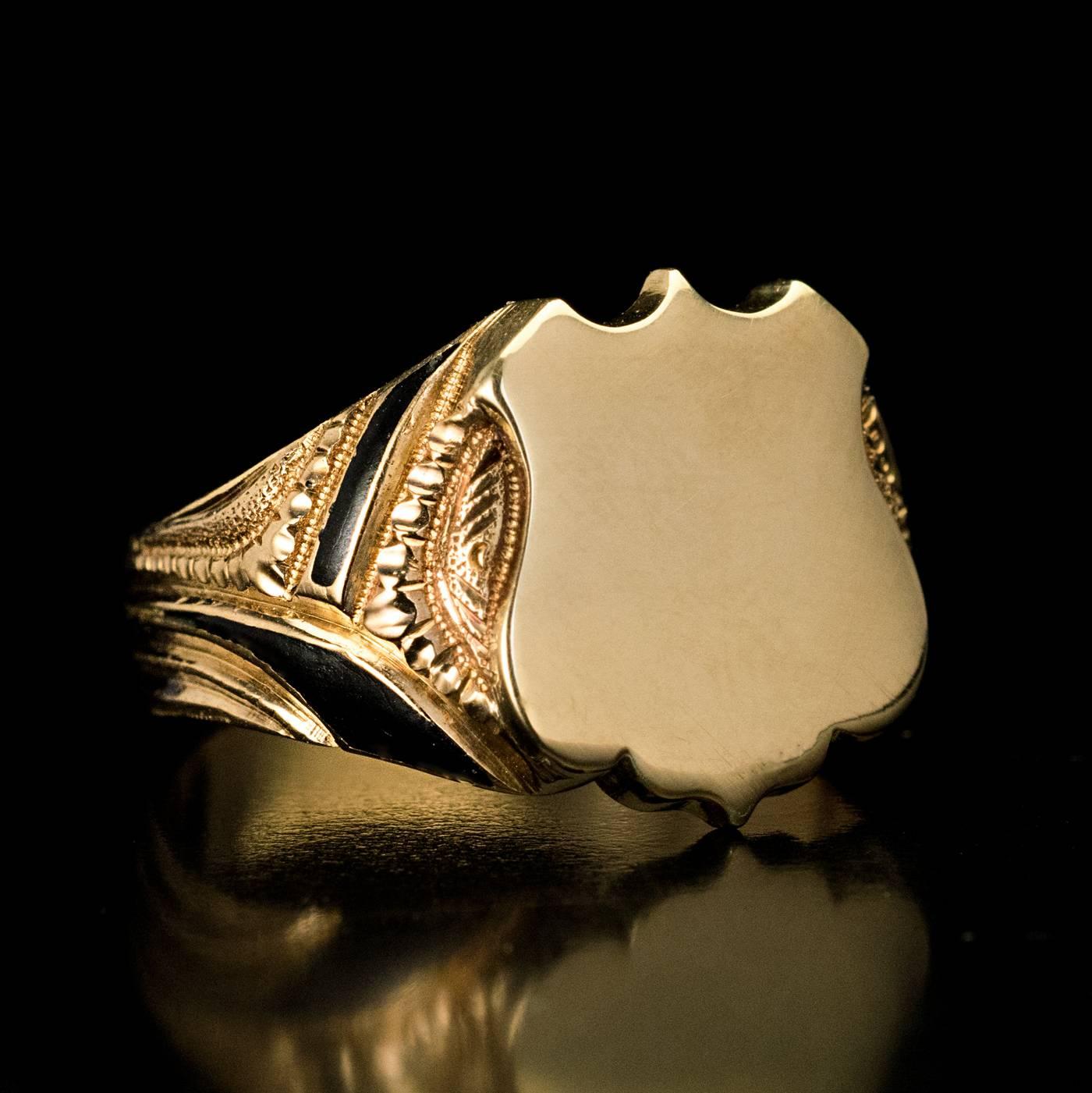 Made in Moscow in the 1880s

An antique 14K gold men’s ring is centered with a polished gold shield flanked by chased and engraved designs with black enamel accents. The ring is marked with 56 zolotnik Imperial gold standard with Moscow assay mark