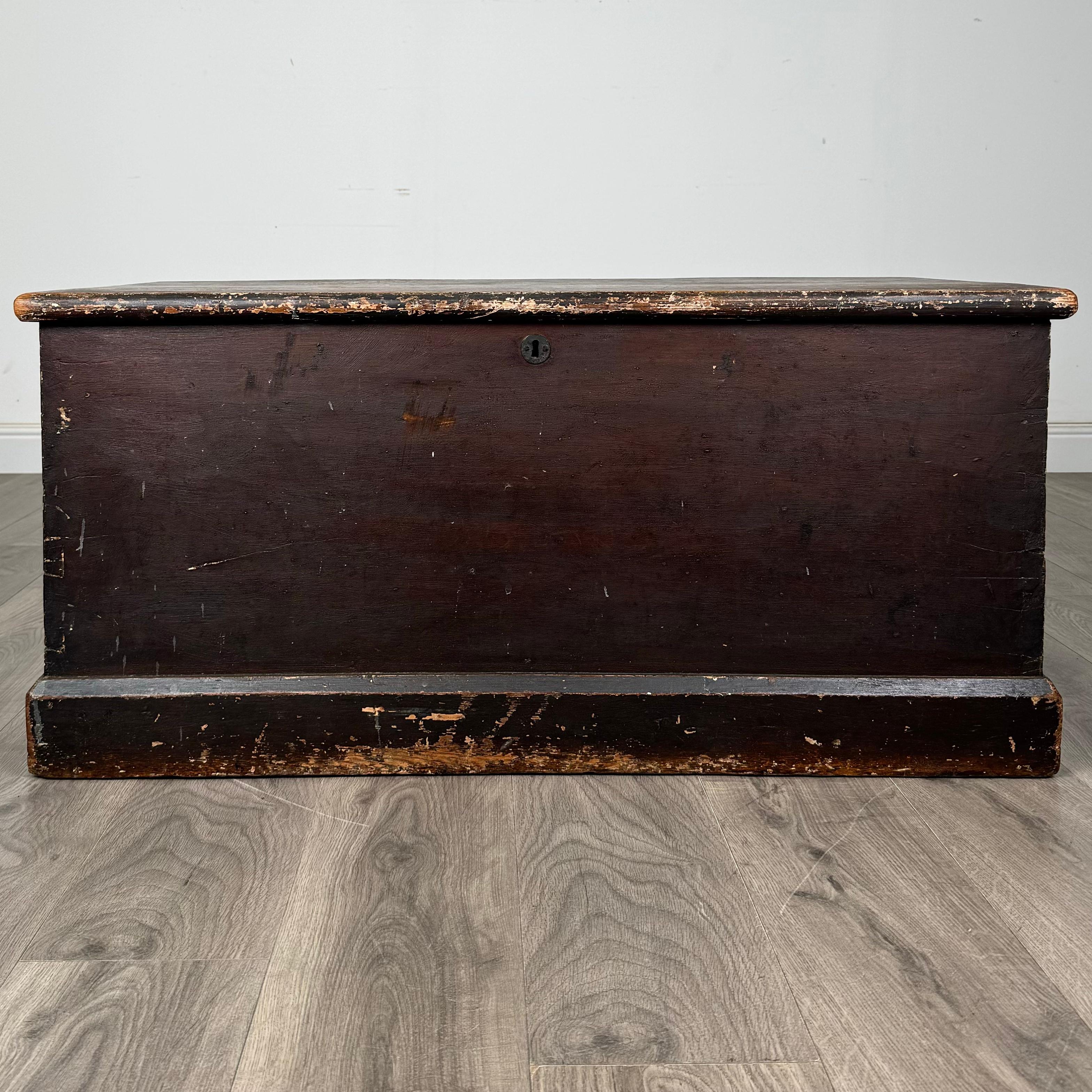 This magnificent 19th-century blanket box, crafted from solid pine, exudes a charming rustic appeal with its beautifully aged painted finish. The paint shows stunning wear that has developed over the years, revealing a gorgeous patina that adds