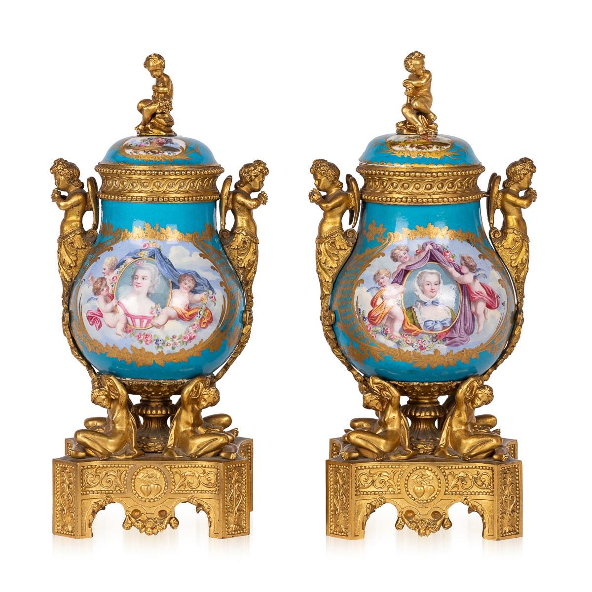 Antique 19th Century French porcelain potpourri vases, adorned with ormolu mounts in the Sèvres style. Each vase boasts two graceful handles shaped like cherubs, adorned with delicate floral motifs cascading down to the base. The lids feature