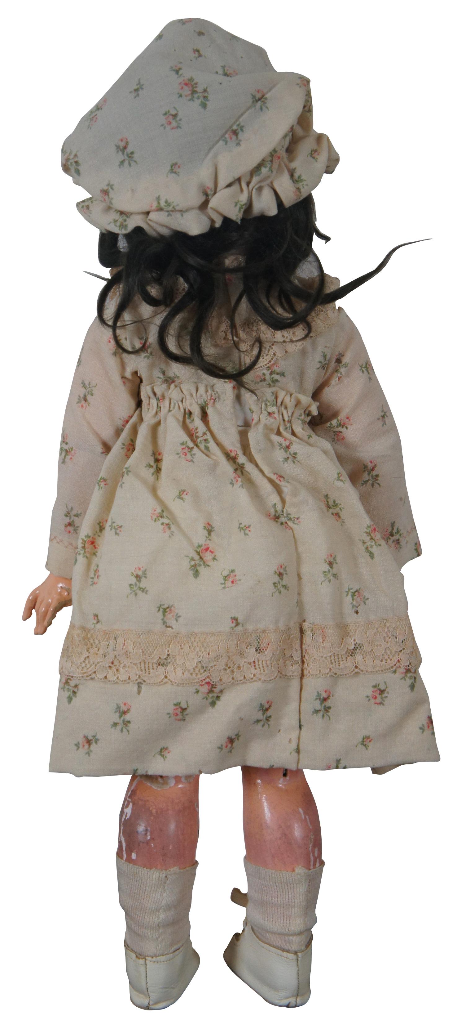 Antique 19th century SFBJ 60 Paris 2 French bisque doll with sleep eyes, brown hair, and articulated jointed limbs, dressed in floral dress and bonnet with leather shoes. Measure: 19