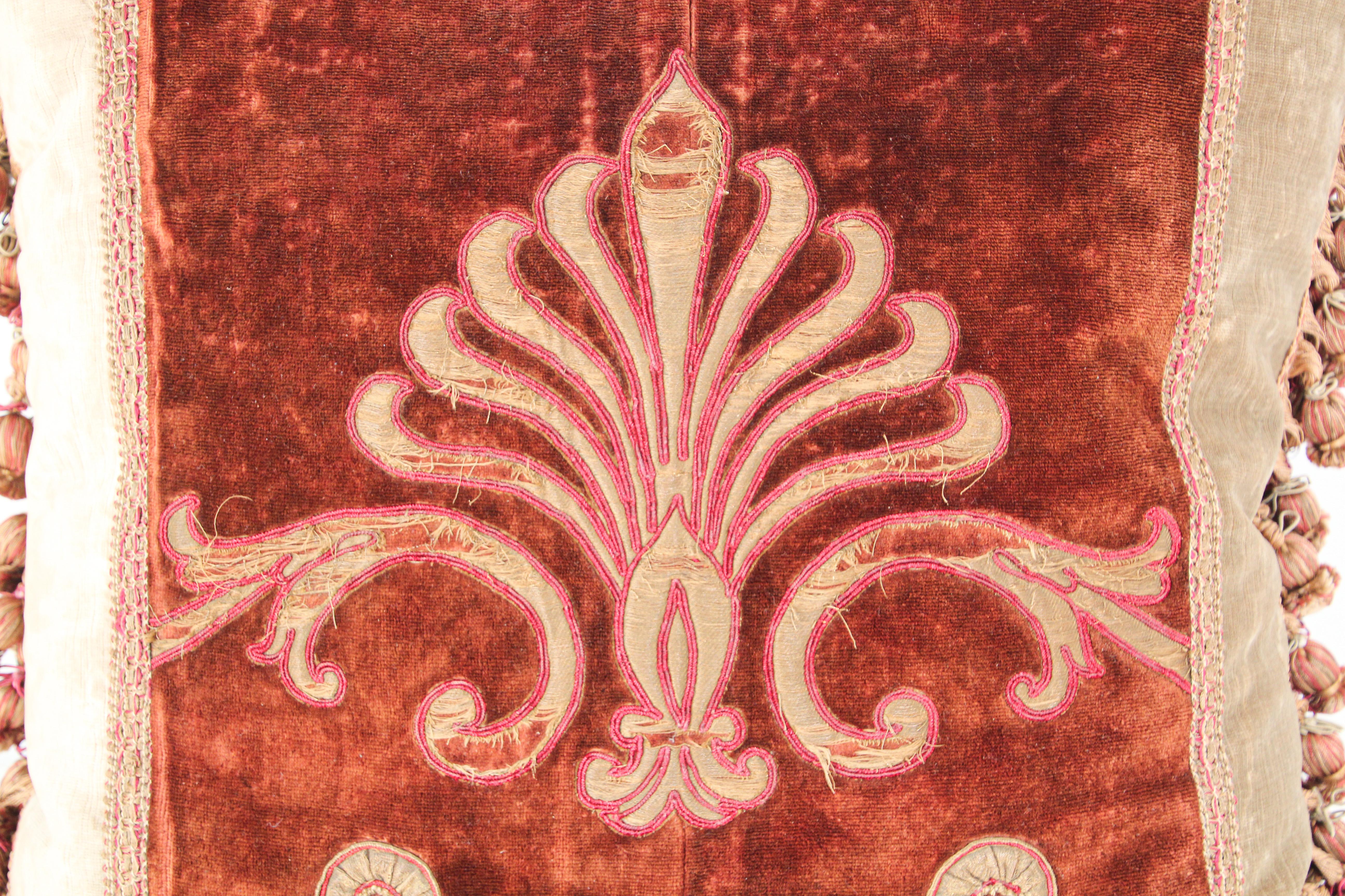 19th century silk velvet antique textile fragment framed into a decorative pillow.
Large square pillow in burgundy on antique green Fortuny style velvet accentuated with metallic gold threads embroidered appliqués designs, tassel trim at four