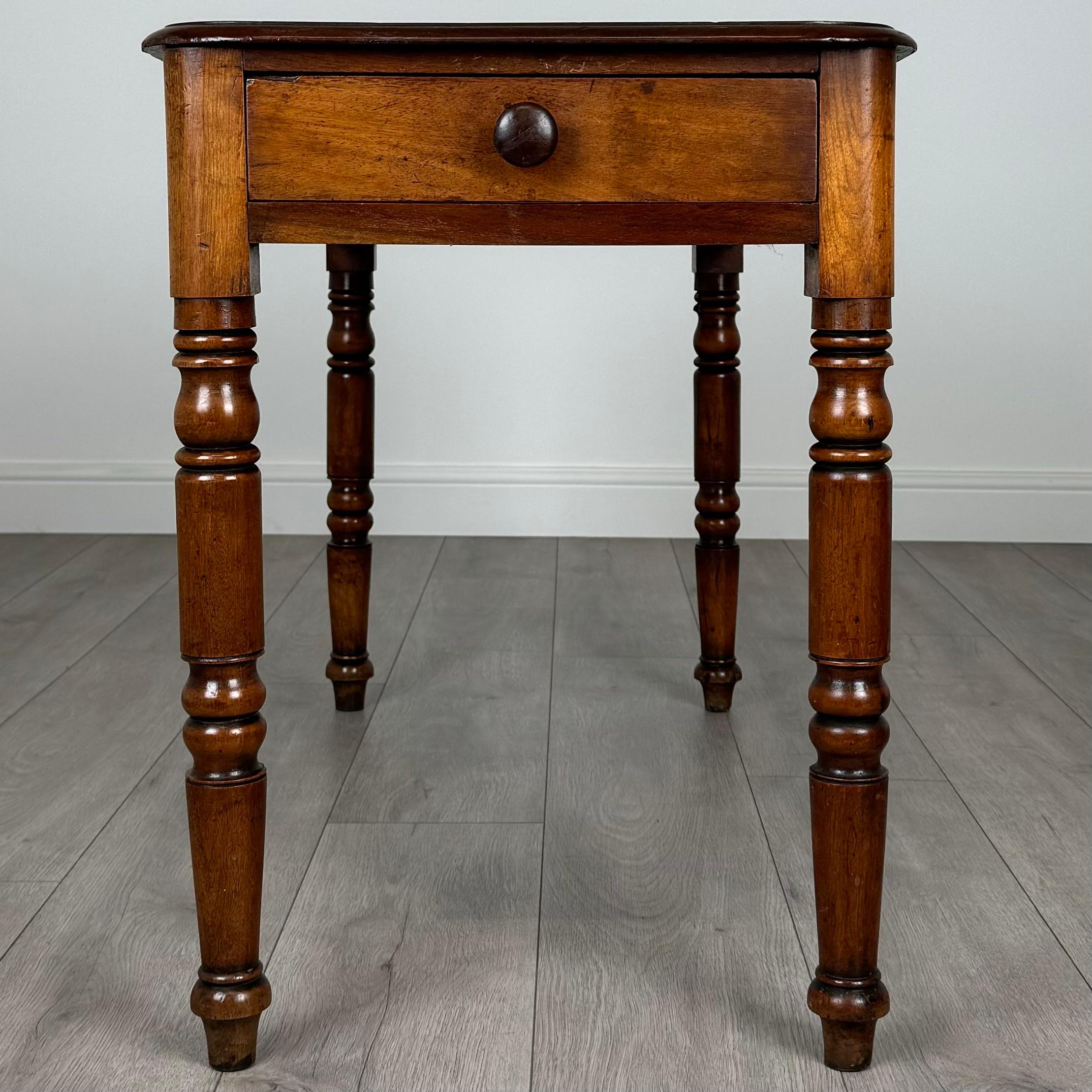 Cette charmante table d'appoint à un tiroir du XIXe siècle, fabriquée dans un riche acajou, est une pièce magnifiquement conçue qui allie élégance et praticité. 
Reposant sur des pieds finement tournés, la table a une apparence raffinée et
