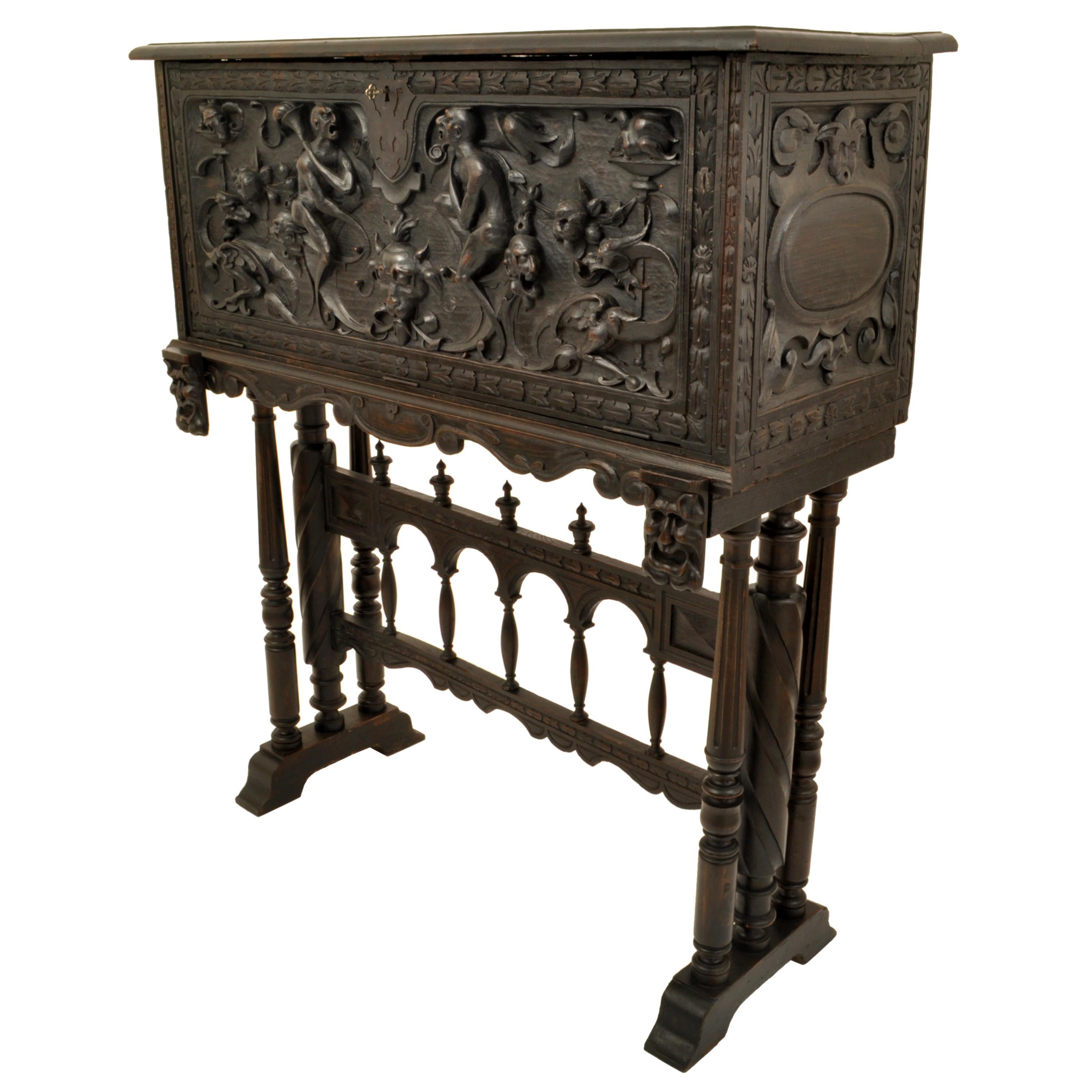 An unusual antique 19th century Spanish Baroque carved vargueno, cabinet on stand circa 1880.
The two section desk and stand is finely carved with baroque grotesques carrying torches, with mythical beasts including a pair of griffins. The desk