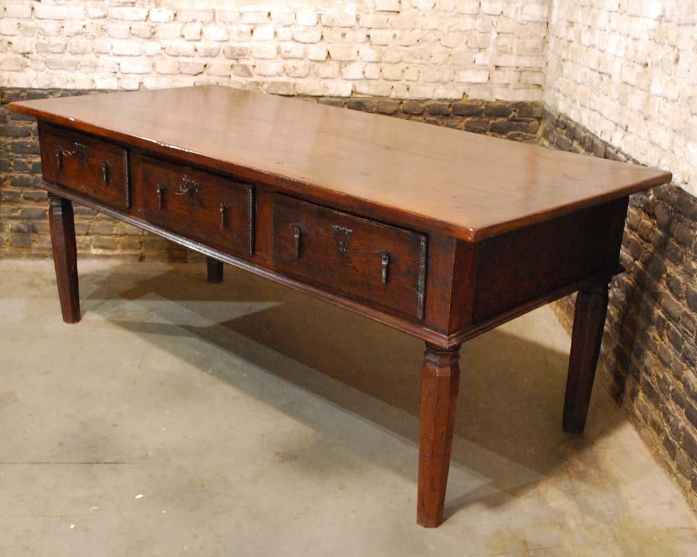 A unique table with hand carved tapered octagonal legs with three drawers above. The drawers have their original drawer pulls and keyplates. Two of them are equipped with the original lock and key. The third drawer never had a lock. The table